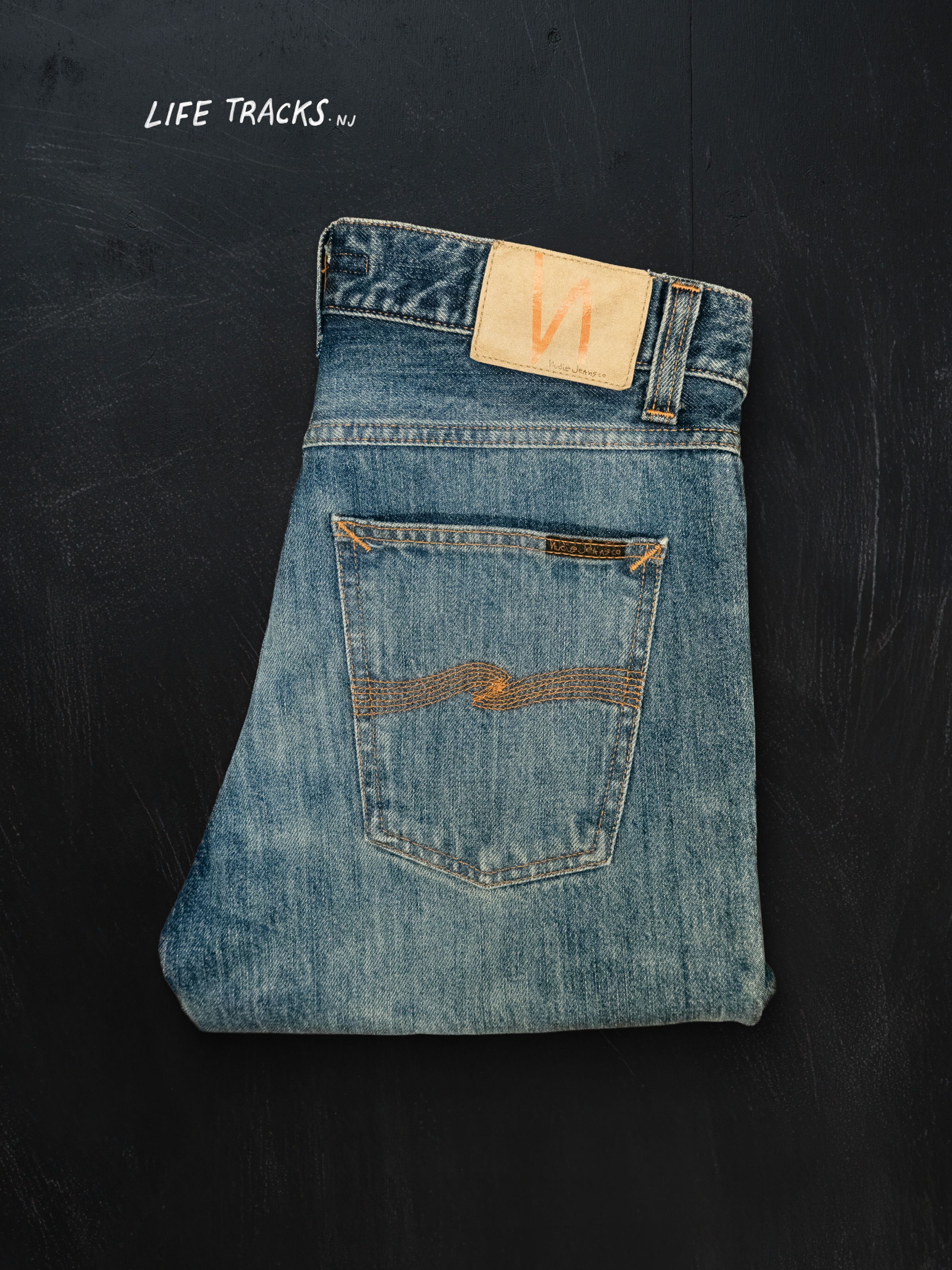 Nudie Jeans Gritty Jackson Thriller Tracks, men's regular fit jeans laid flat and folded in half.