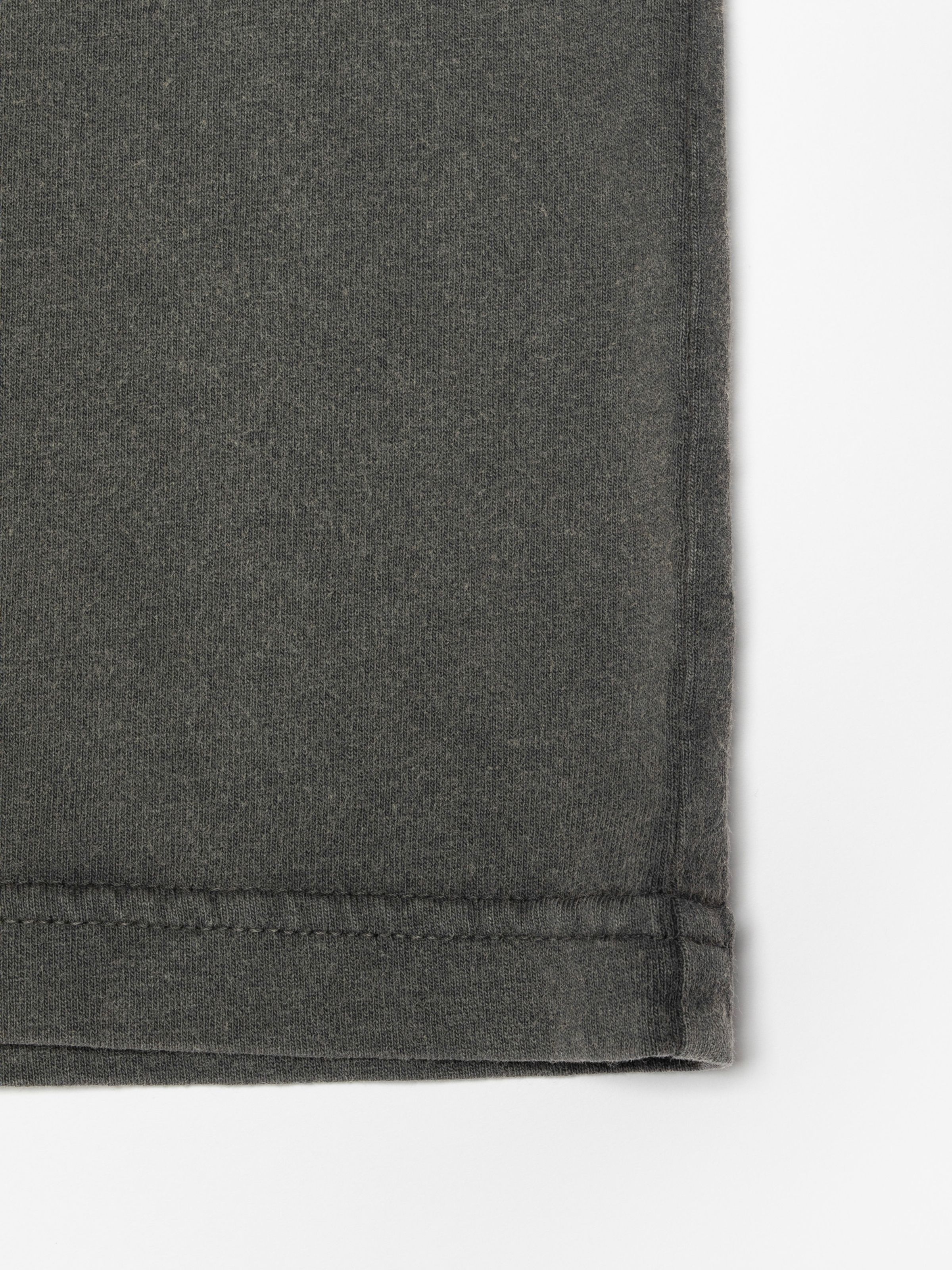 Nudie Jeans Roy T-Shirt Make Sense Antracite, close-up of the hem showing the garment-dyed organic cotton fabric.