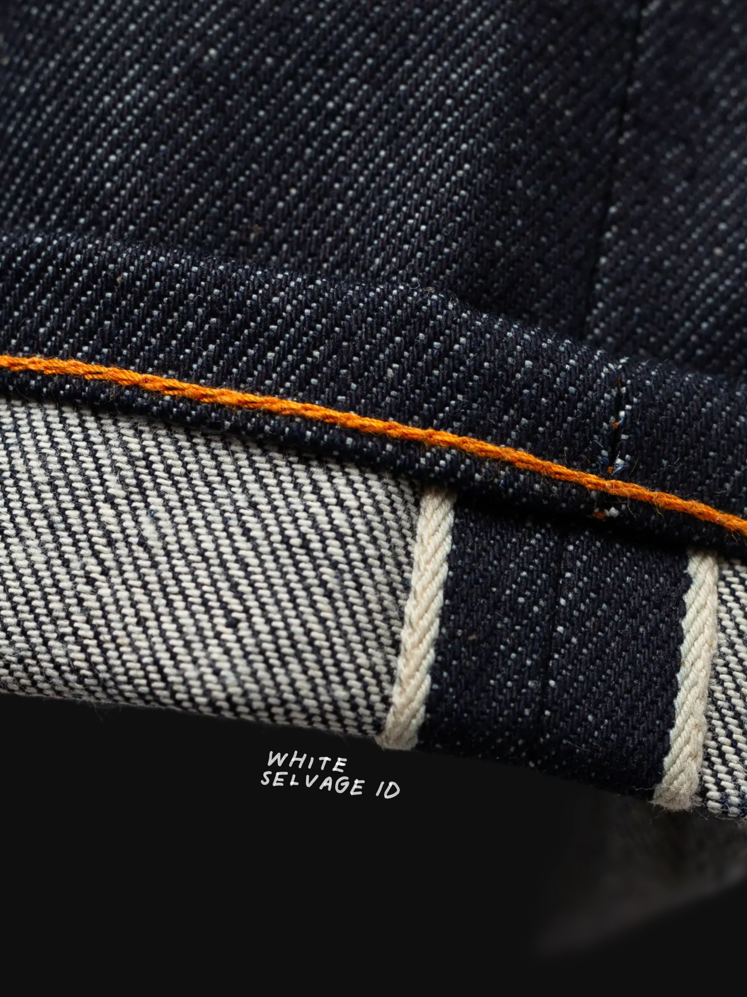 Nudie Jeans Gritty Jackson Dry Dusk Selvage, Nahaufnahme des Beinabschlusses mit weißer selvedge ID und orangefarbenem Faden.
