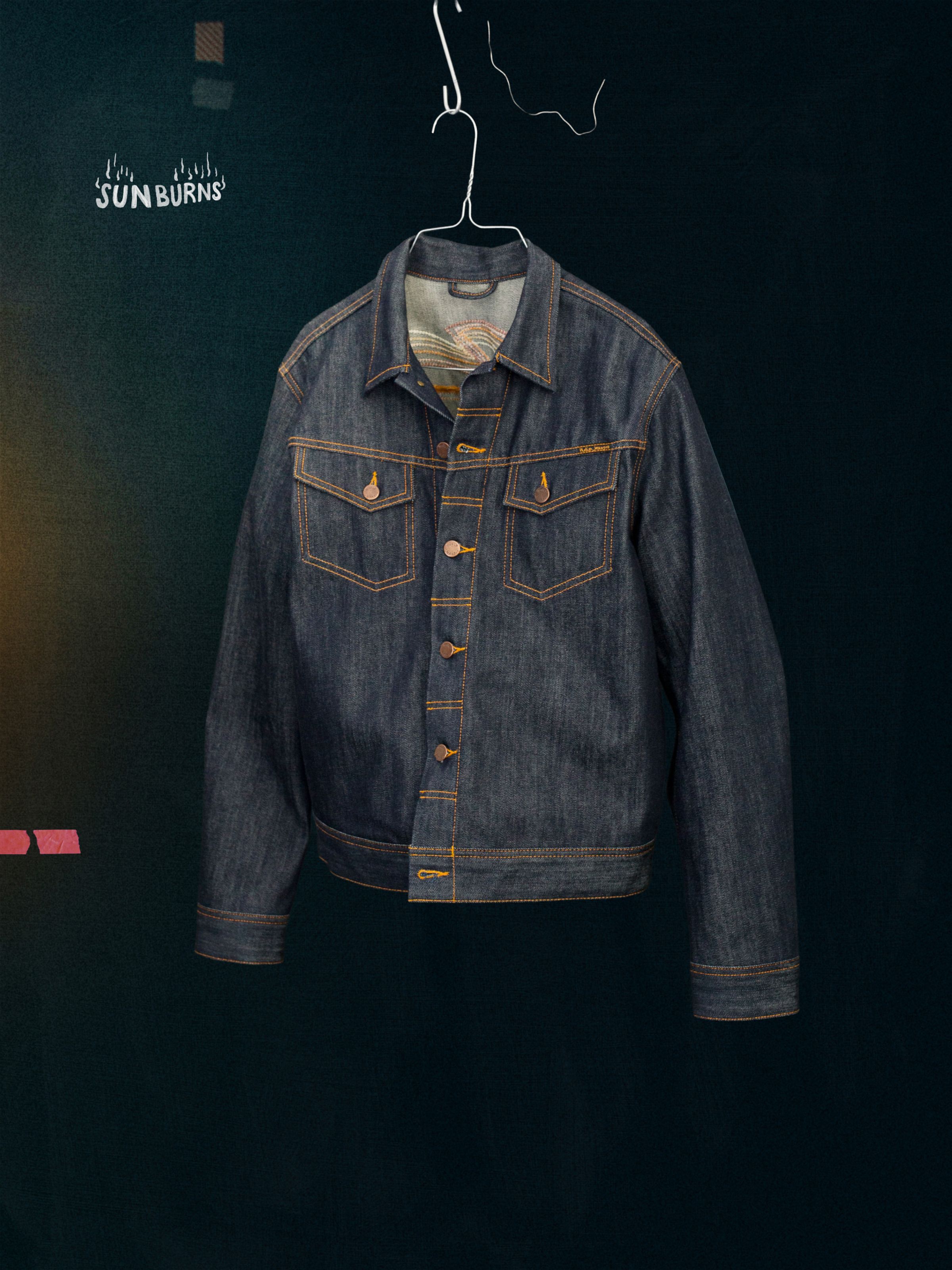 Nudie Jeans Conny Denim Jacket Sunburns, a men's slim fit denim jacket in dry blue denim, shown hanging flat.