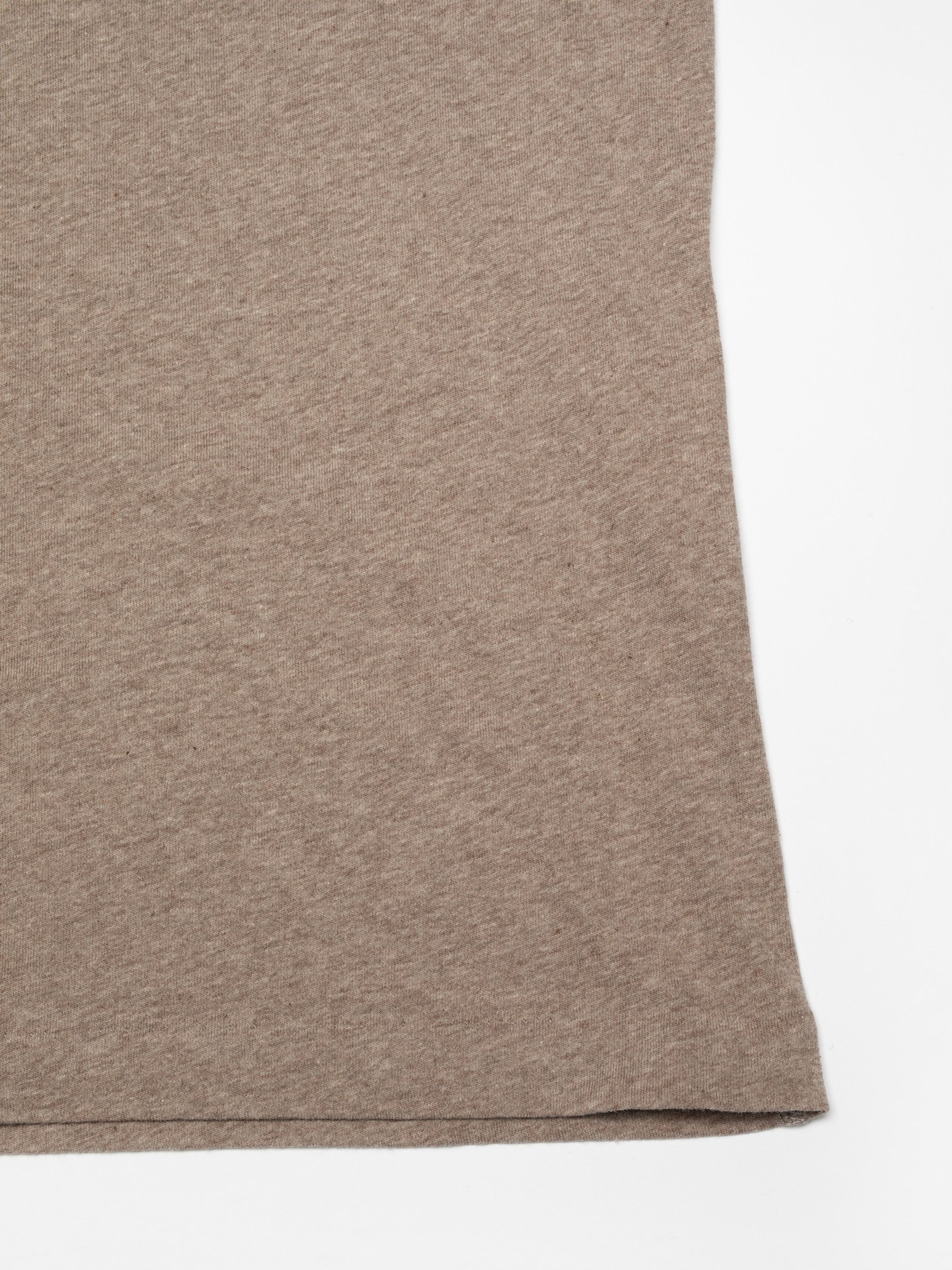 Nudie Jeans Eve Scratchy Dog T-Shirt in Beigemelange, a close-up shot showing the texture of the soft organic cotton fabric.