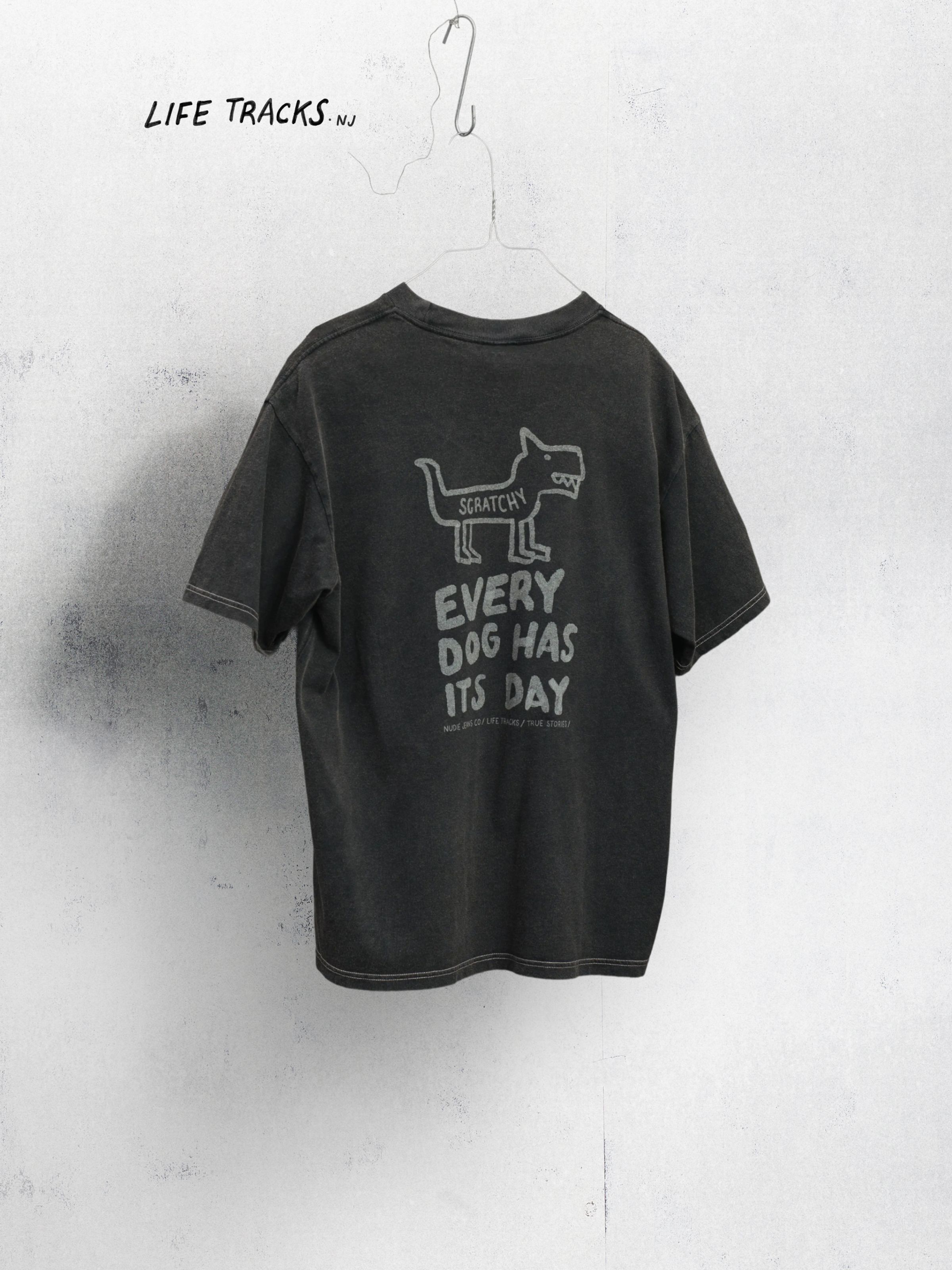 Nudie Jeans Koffe Scratched Tracks T-Shirt in Antracite, a men's relaxed fit tee shown from the back on a hanger.