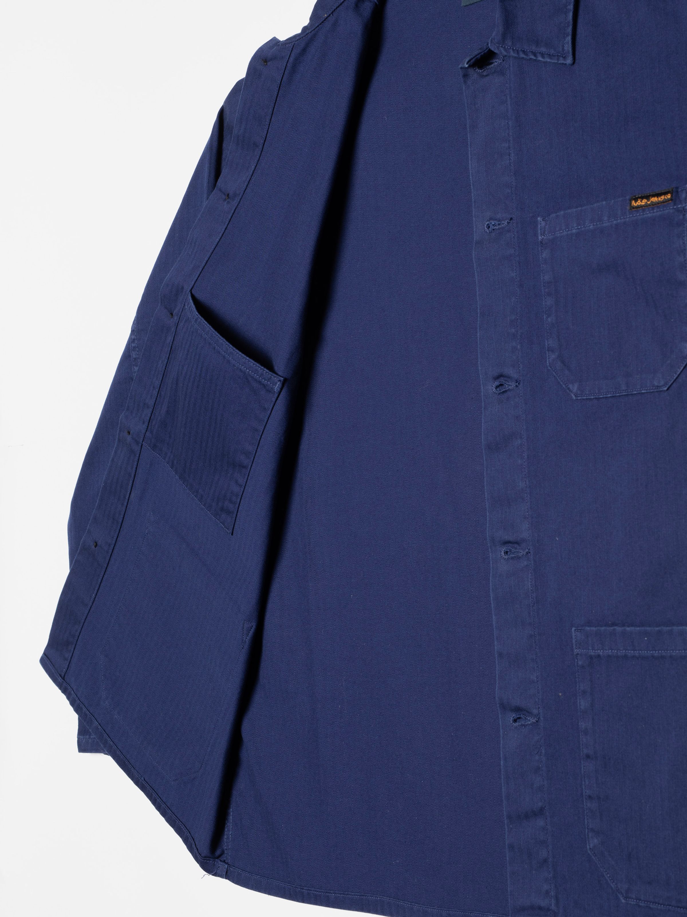 Nudie Jeans Buddy Chore Jacket Herringbone, a men's jacket in deep blue, showing a detail view of the inside pocket.