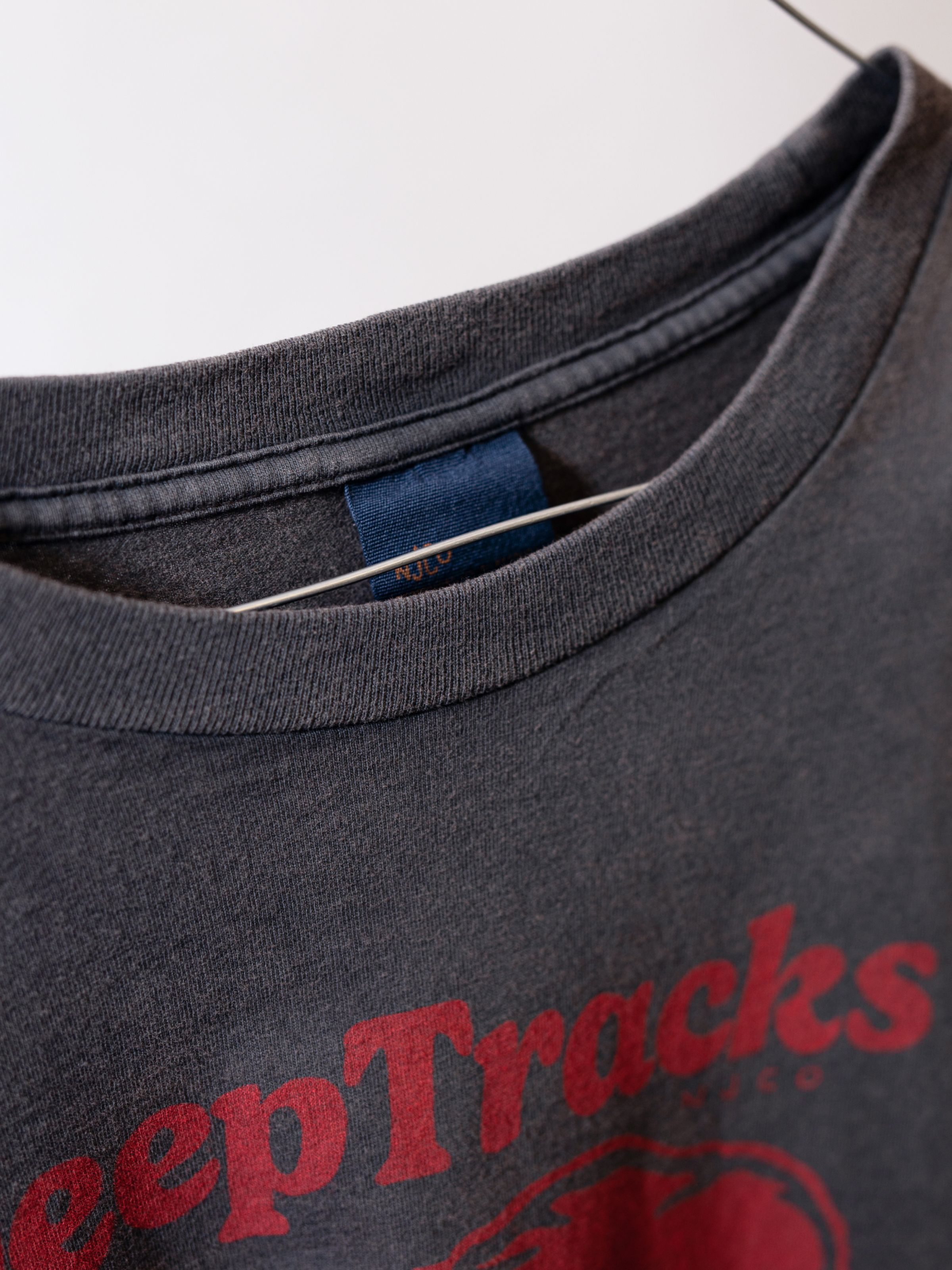 Nudie Jeans Roy Deep Tracks T-Shirt in Antracite, a men's t-shirt, showing a close-up of the collar and chest print.