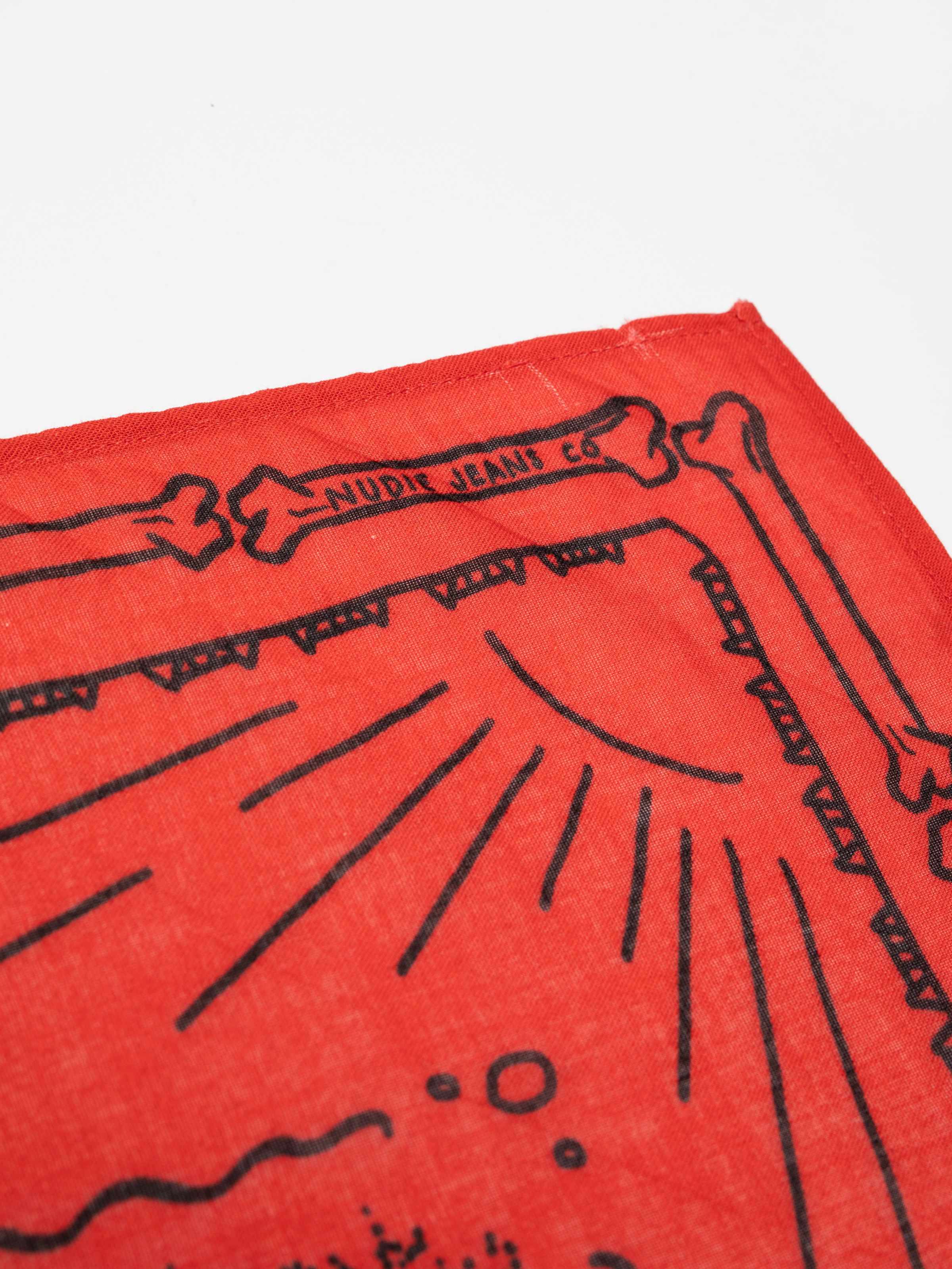 Nudie Jeans Ingrid Bandana in Double Cross Red, with a close-up detail of the custom corner print and logo.