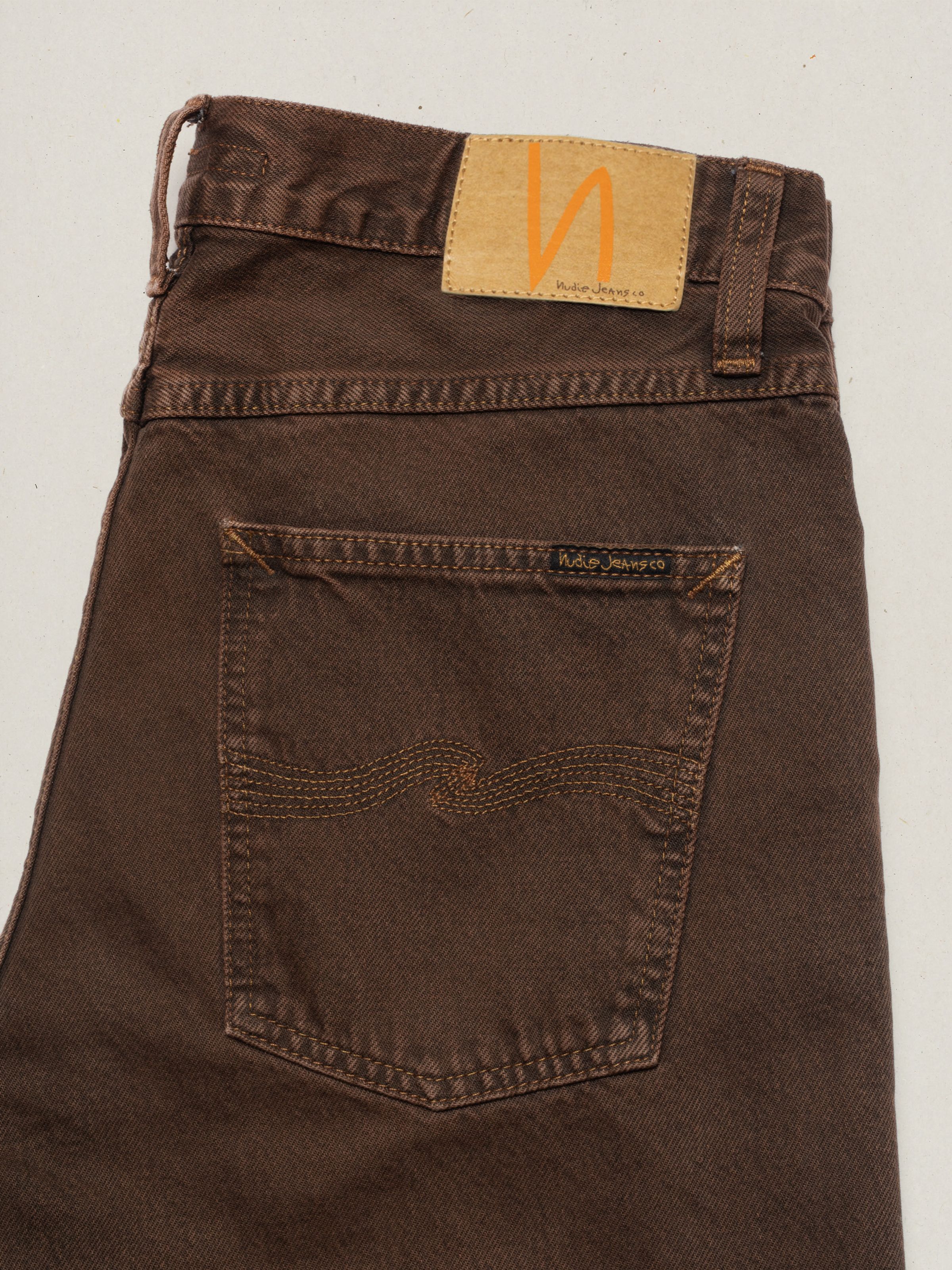 Nudie Jeans Rad Rufus Espresso Bernardini, close-up of the back pocket with signature stitching and Jacron patch.