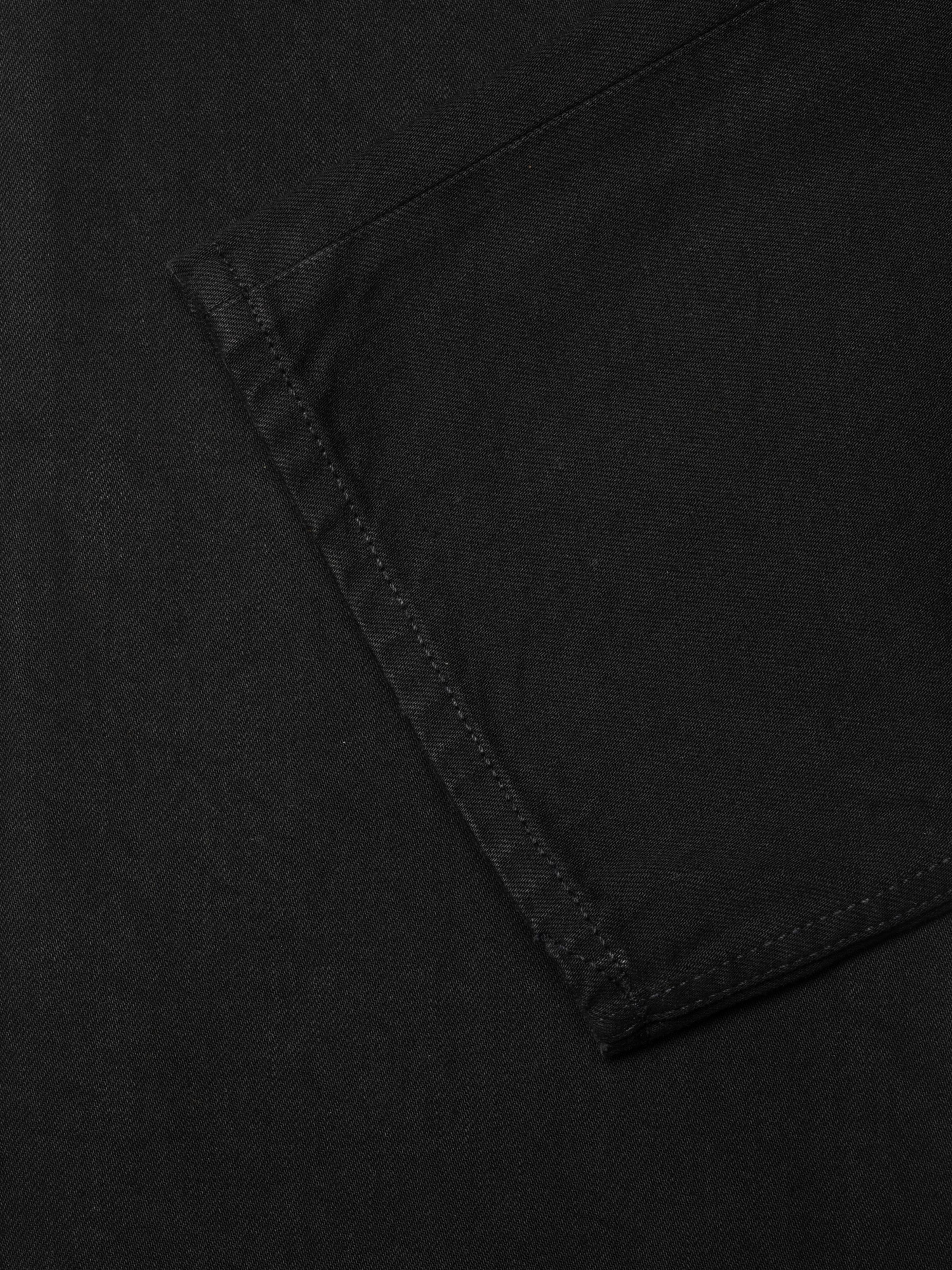 Nudie Jeans Tuff Tony Black Water, men's loose fit jeans in black denim, showing a close-up of the back pocket detail.
