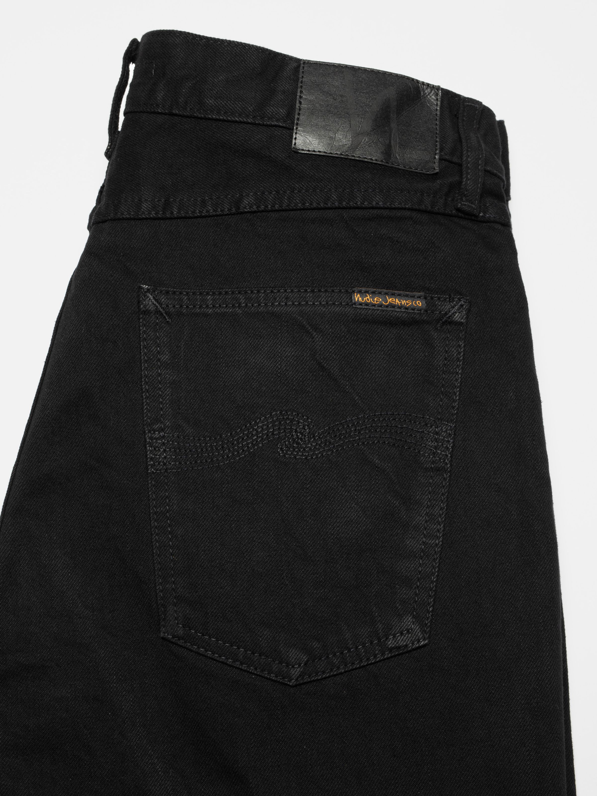 Nudie Jeans Tuff Tony Black Water, a pair of men's loose fit jeans in black, showing a close-up of the back pocket.