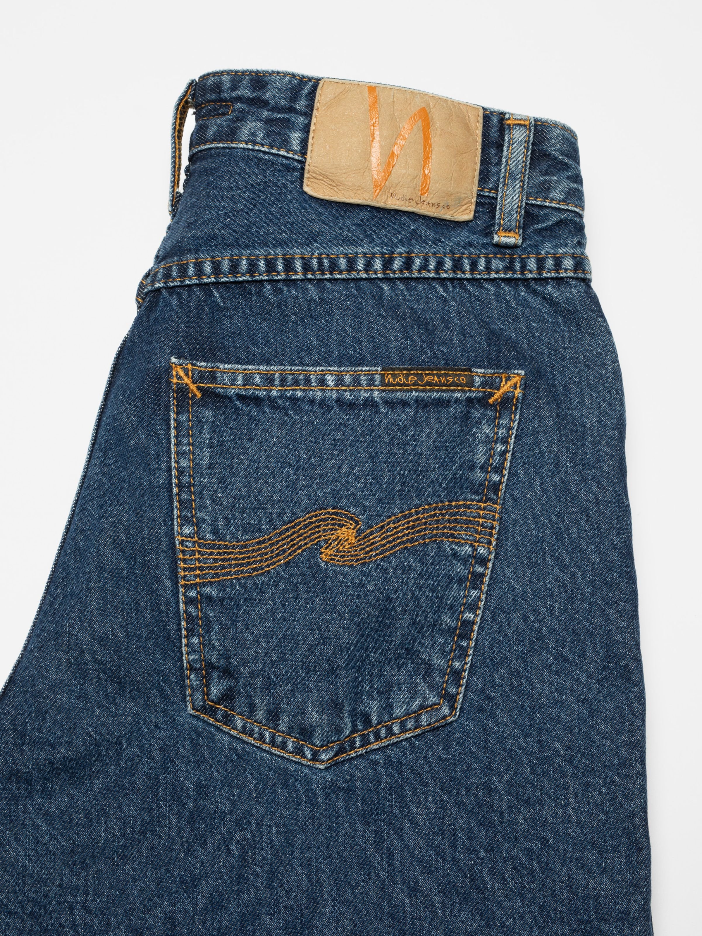 Nudie Jeans Breezy Britt Evening Jazz, a women's regular tapered jean, with a close-up of the back pocket and jacron patch.