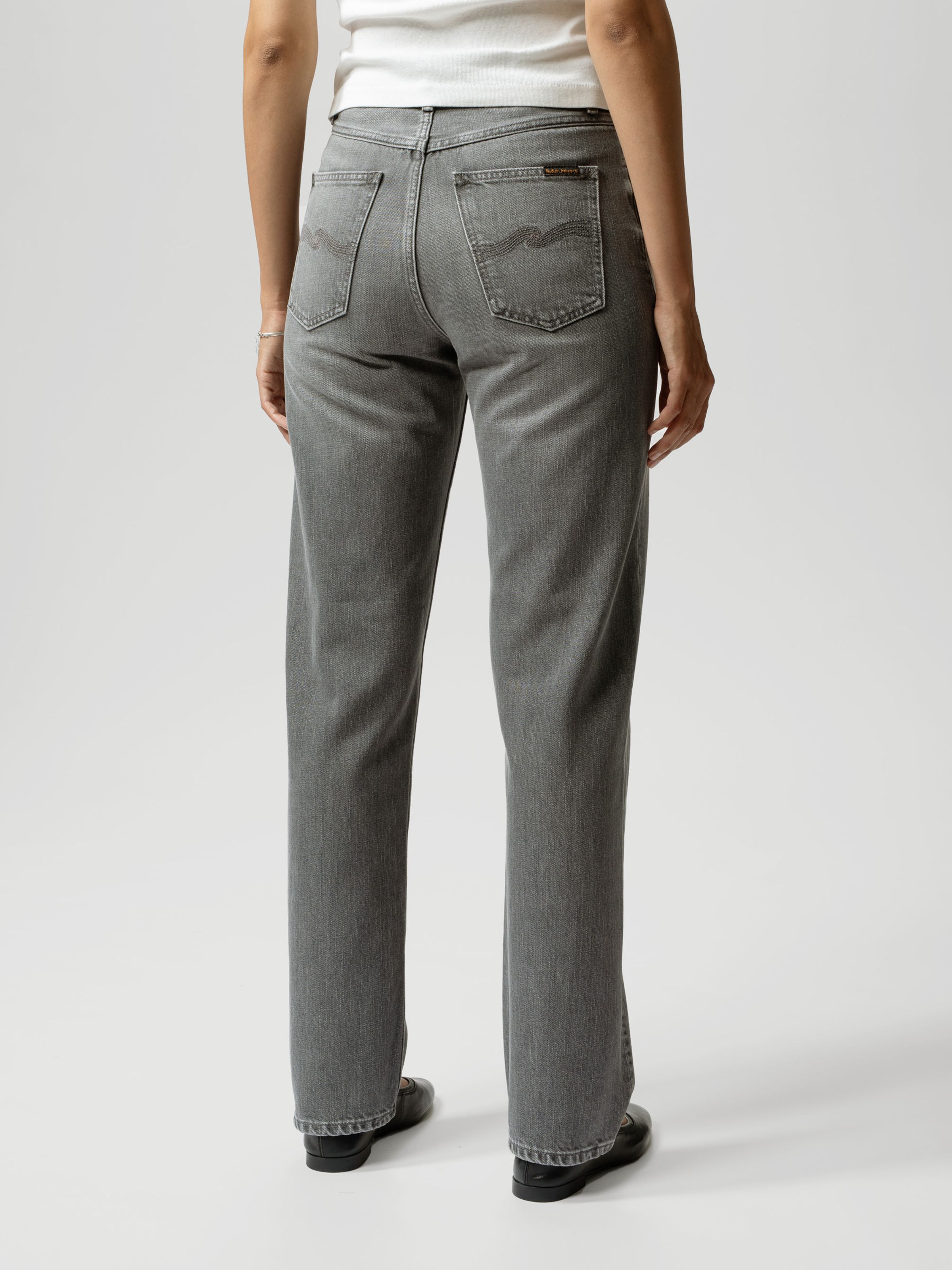 Nudie Jeans Lofty Lo Foggy Grey, a pair of women's regular fit jeans in a grey wash, worn by a model and shown from the back.