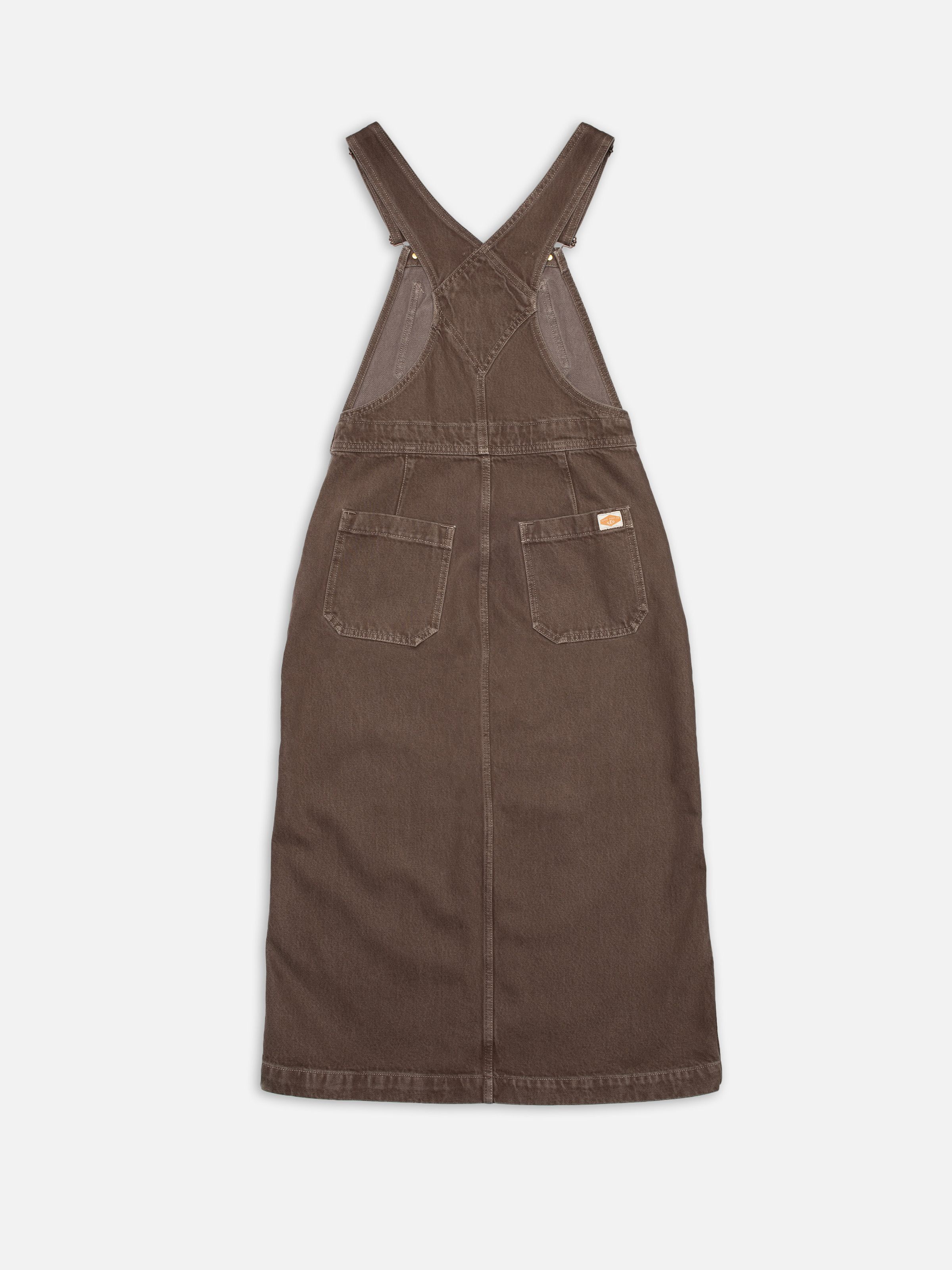 Nudie Jeans Inger Dungarees Dress Espresso, a women's dungaree dress in espresso brown denim, shown laid flat from the back.