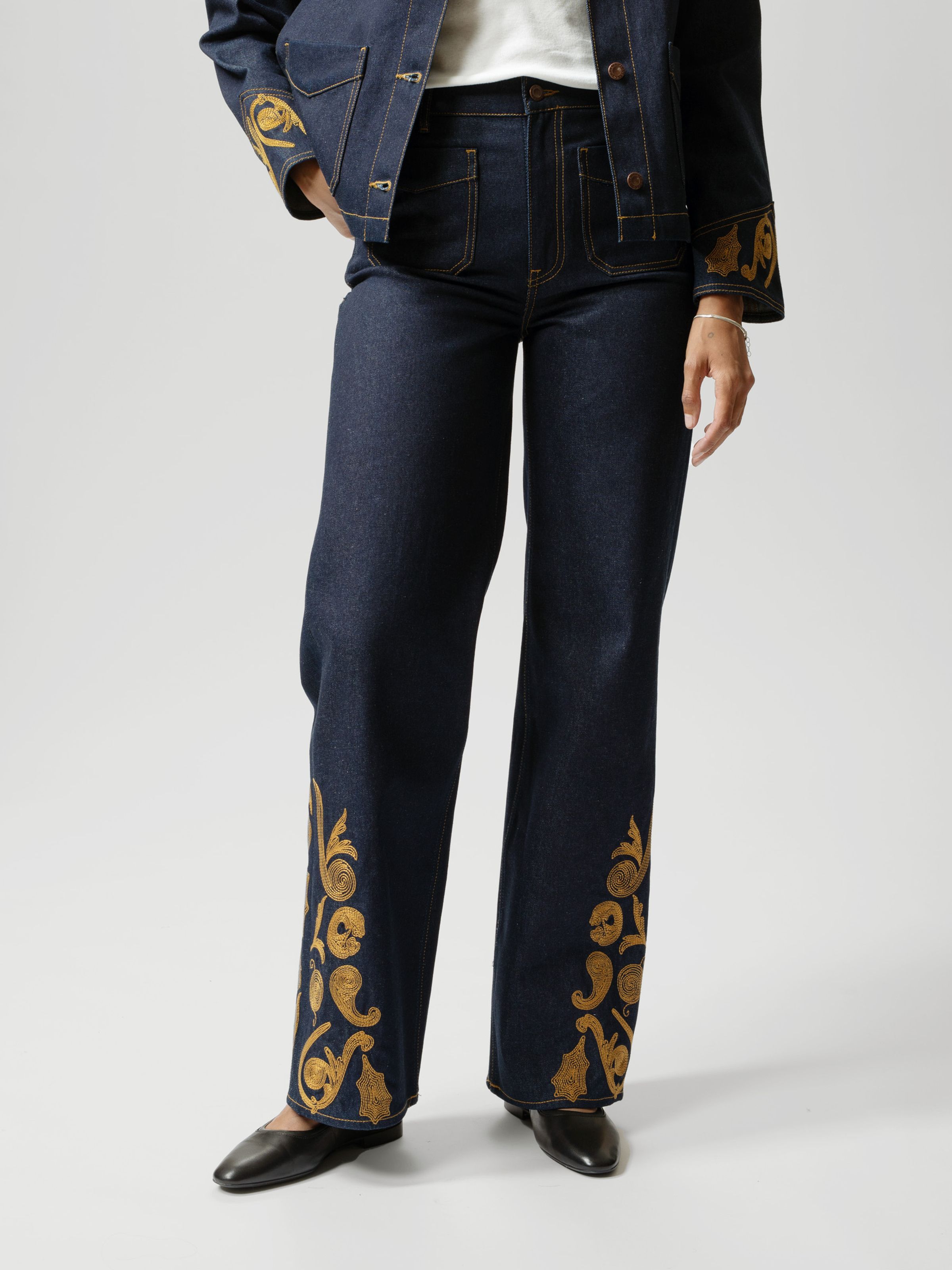Nudie Jeans Holly Western Pants, women's flared pants in dry denim with embroidery, worn by a model and shown from the front.
