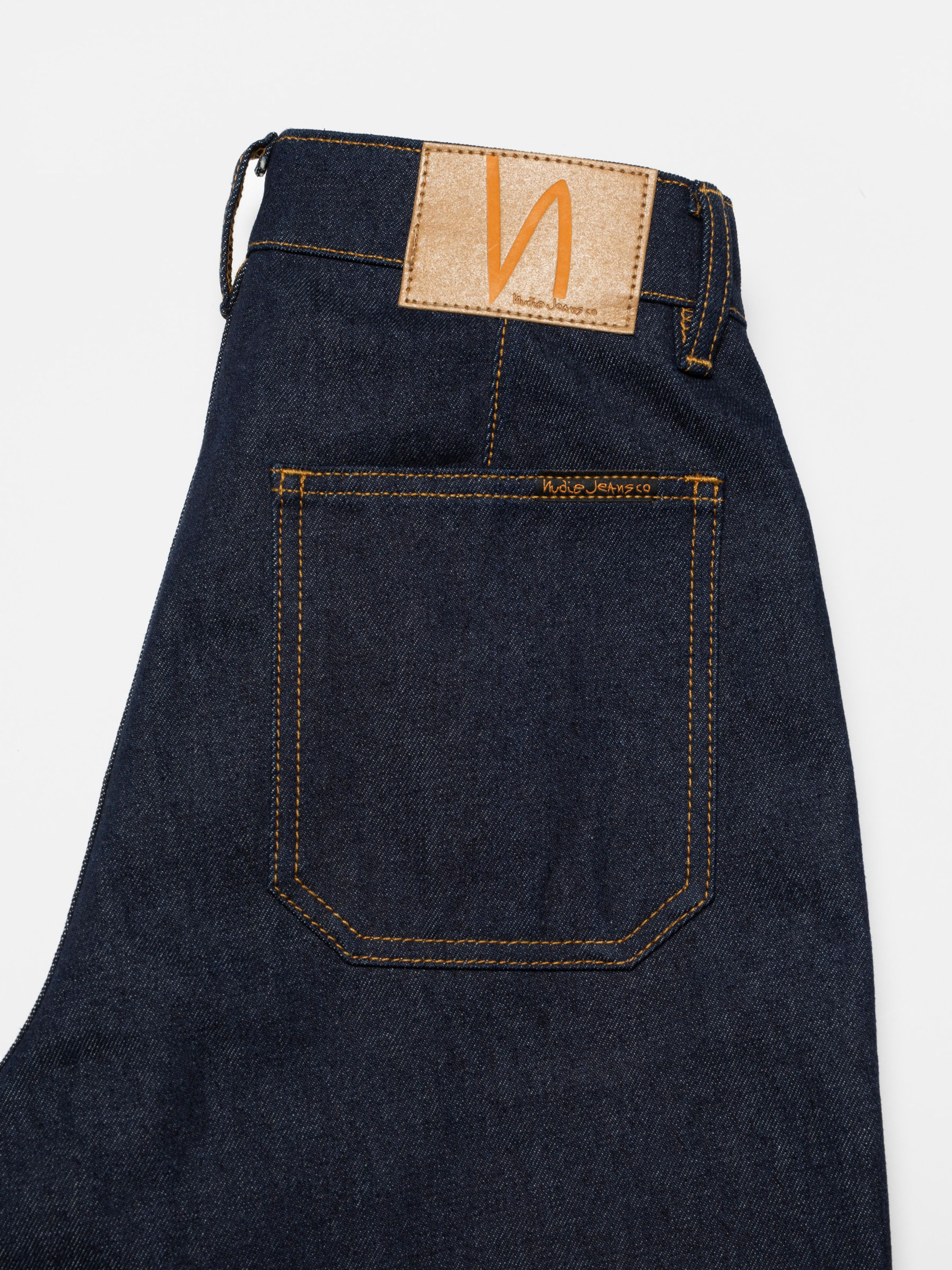 Nudie Jeans Holly Western Pants, women's flared jeans in dry denim, showing a close-up of the back pocket and patch.