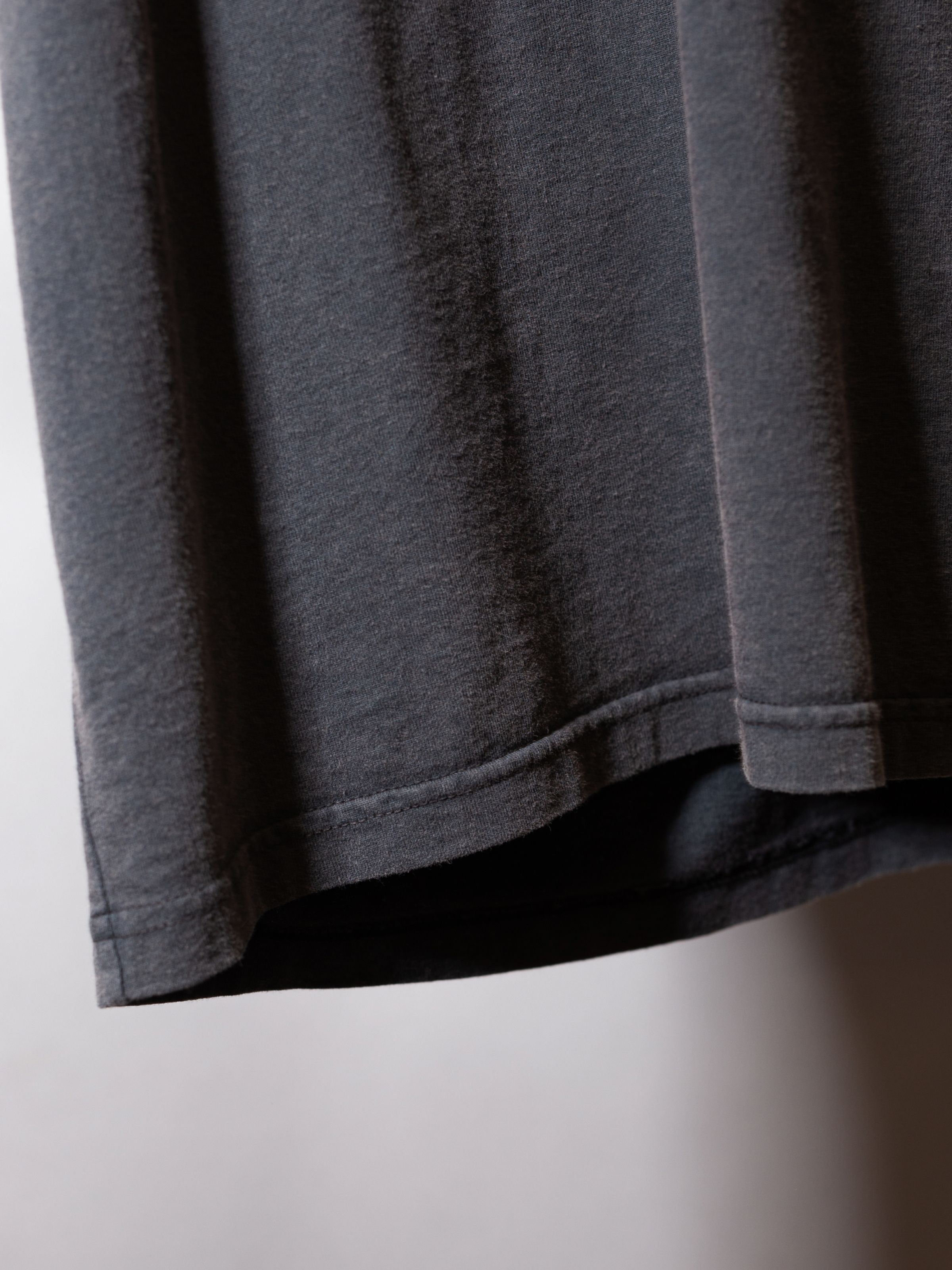 Nudie Jeans Roy Night Tracks T-Shirt in Antracite, a close-up detail shot of the organic cotton fabric and hem.
