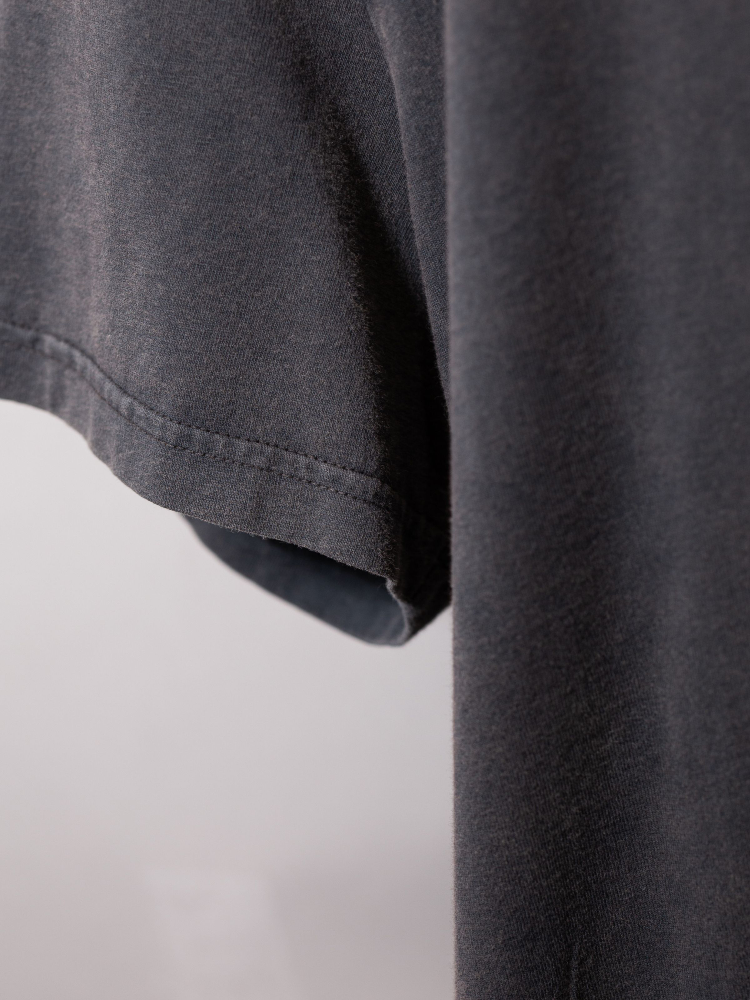 Nudie Jeans Roy Night Tracks T-Shirt in Antracite, a men's t-shirt, shown in a close-up of the sleeve and fabric texture.