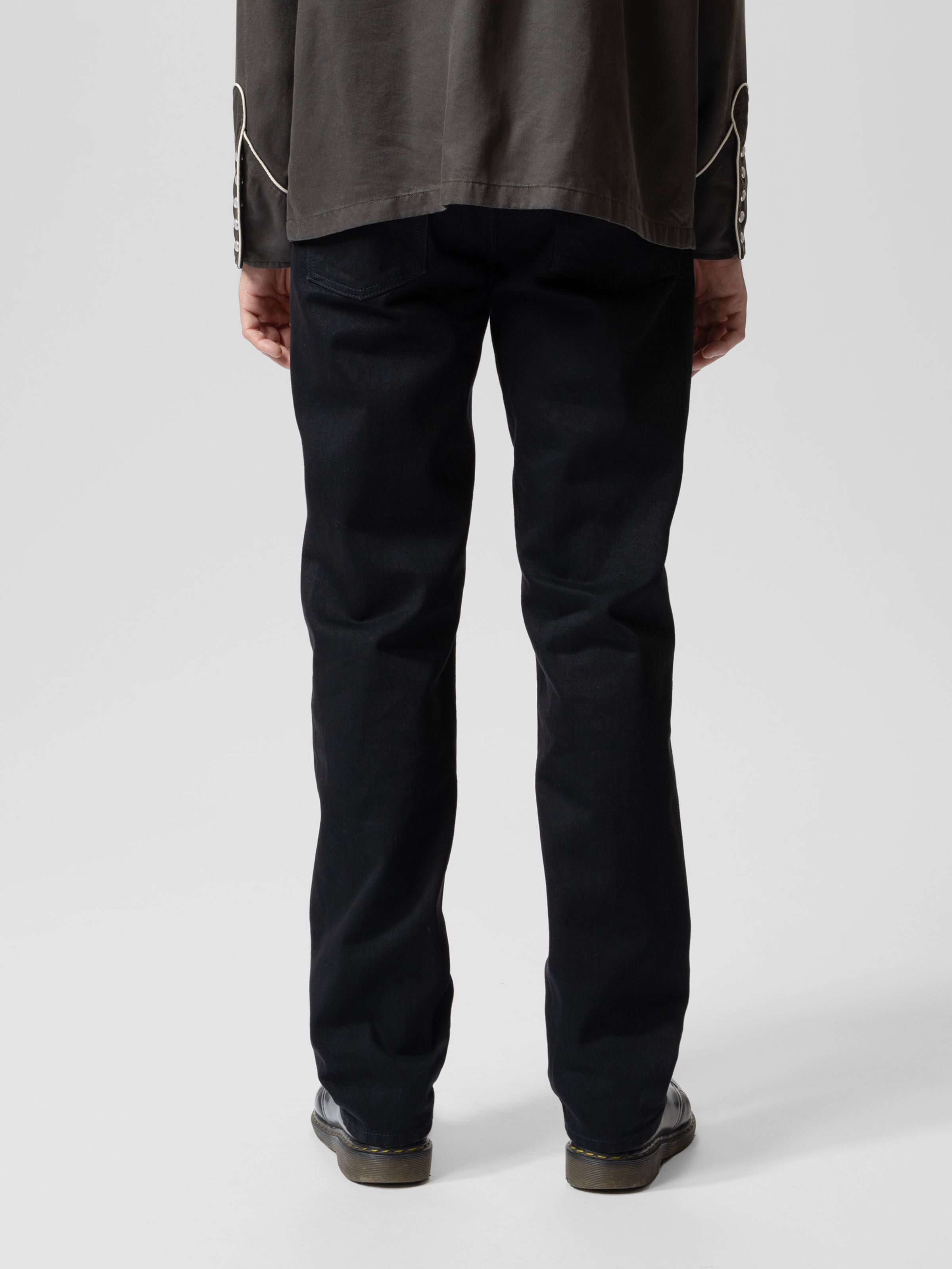 Nudie Jeans Rad Rufus Black Water, a men's regular fit straight leg jean, worn by a model and shown from the back.