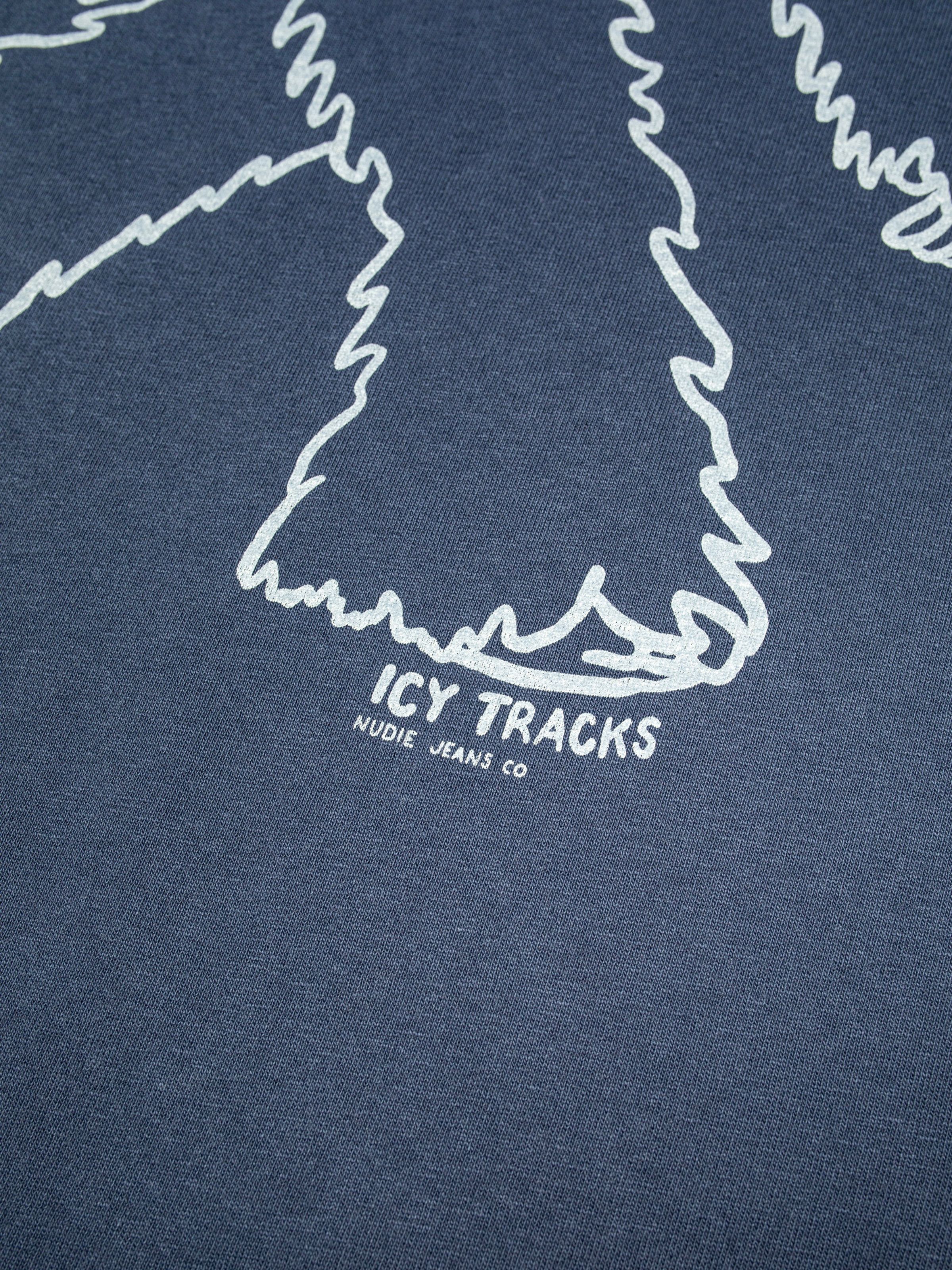 Nudie Jeans Roy Icy Tracks T-Shirt in dark blue, close-up showing the chest print with the text 'Icy Tracks Nudie Jeans Co'.