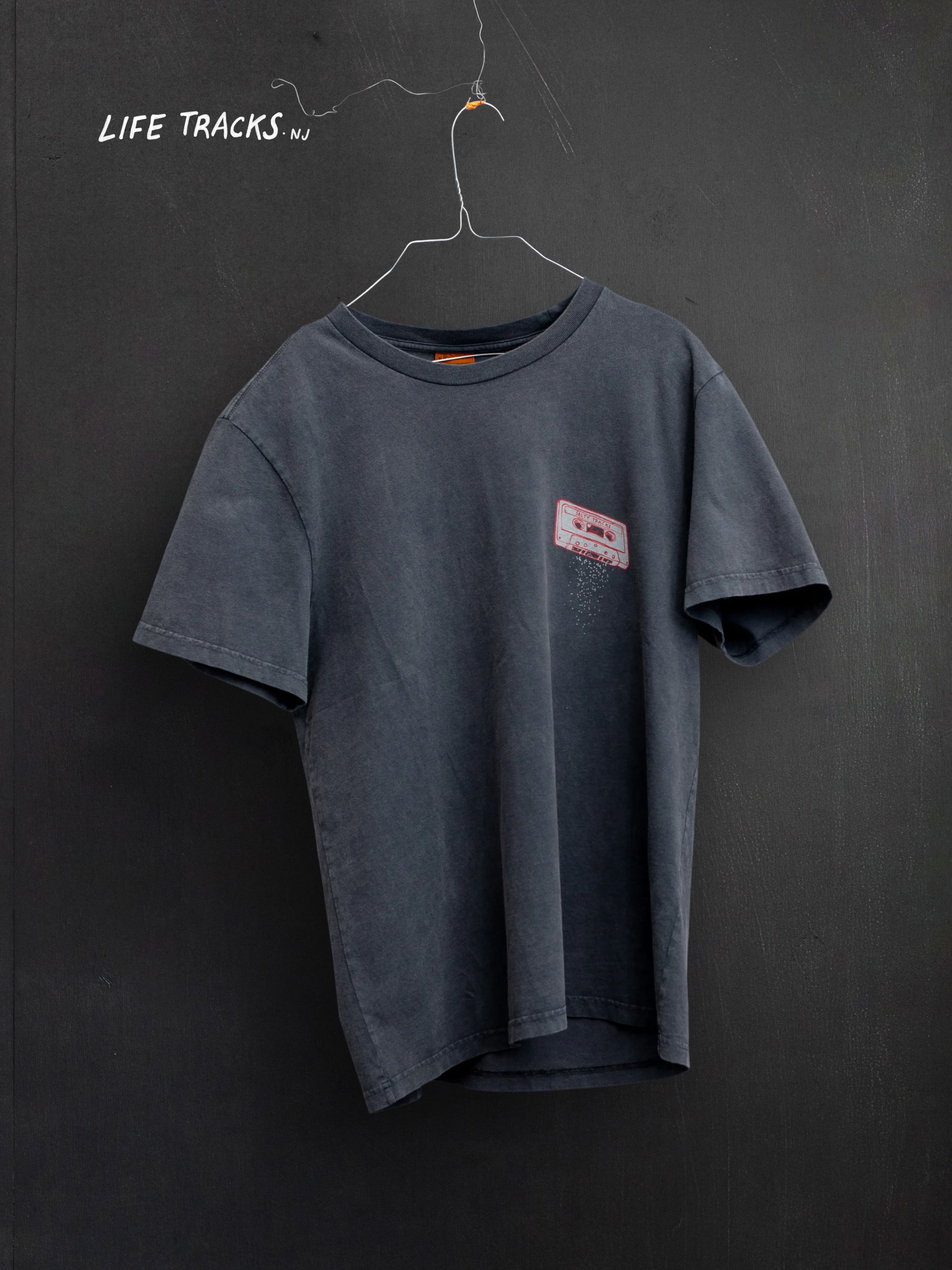 Nudie Jeans Roy Salty Tracks T-Shirt, a grey men's t-shirt shown as a flatshot hanging on a wall.