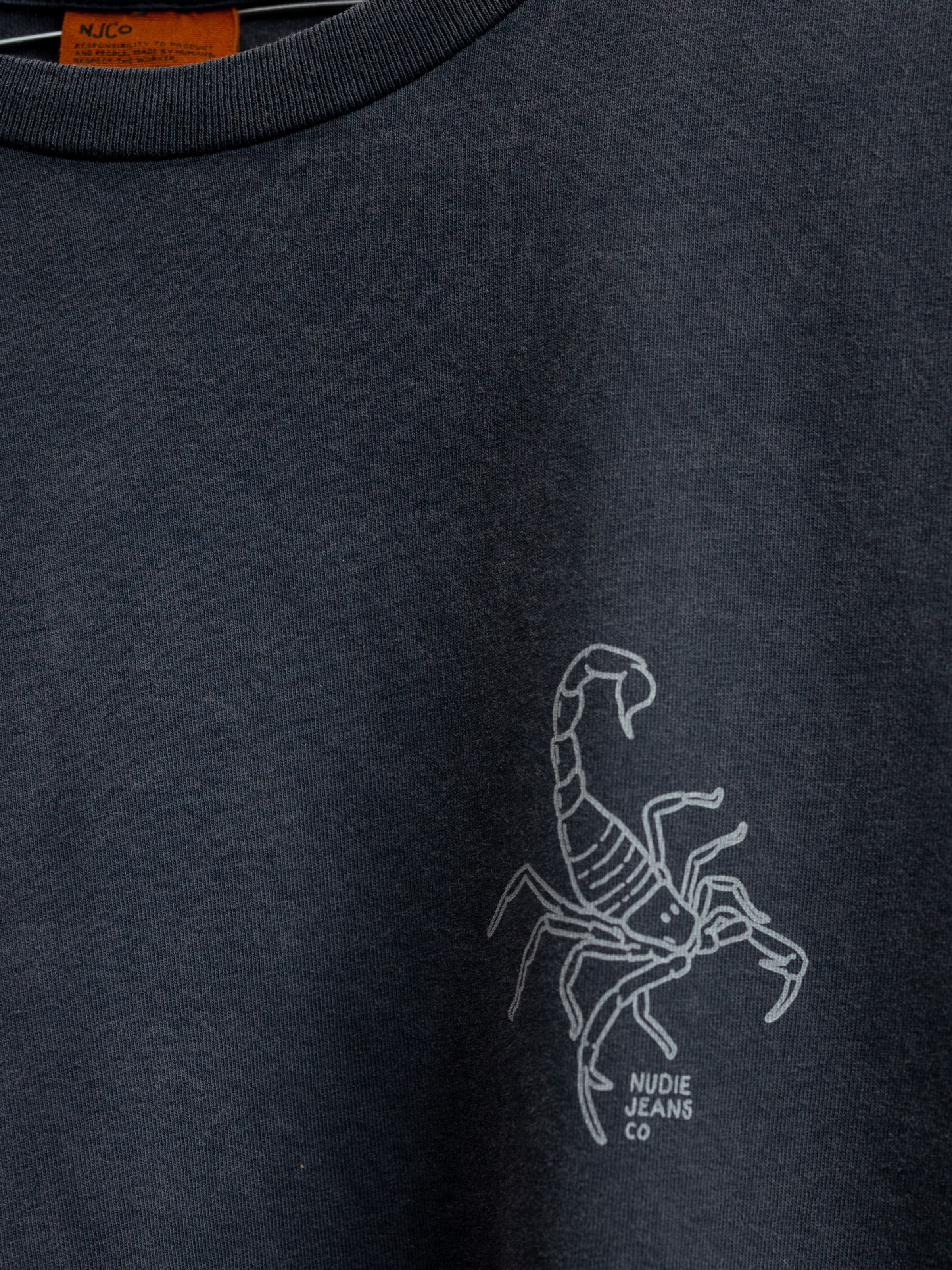 Nudie Jeans Roy Sand Tracks T-Shirt, a close-up showing the small scorpion print on the chest.