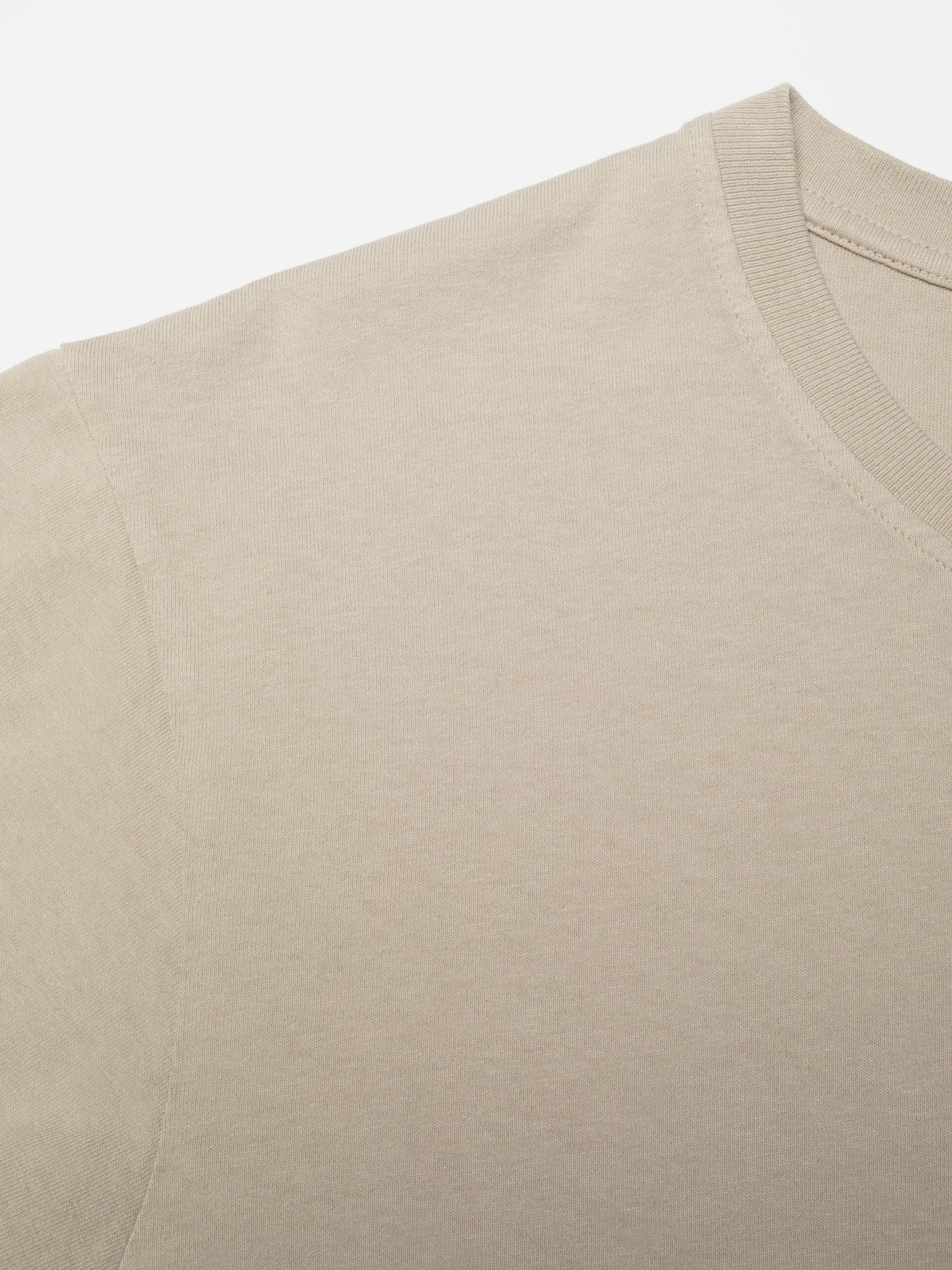 Nudie Jeans Uno Everyday T-Shirt in Sand, close-up view of the ribbed crew neck and organic cotton jersey.