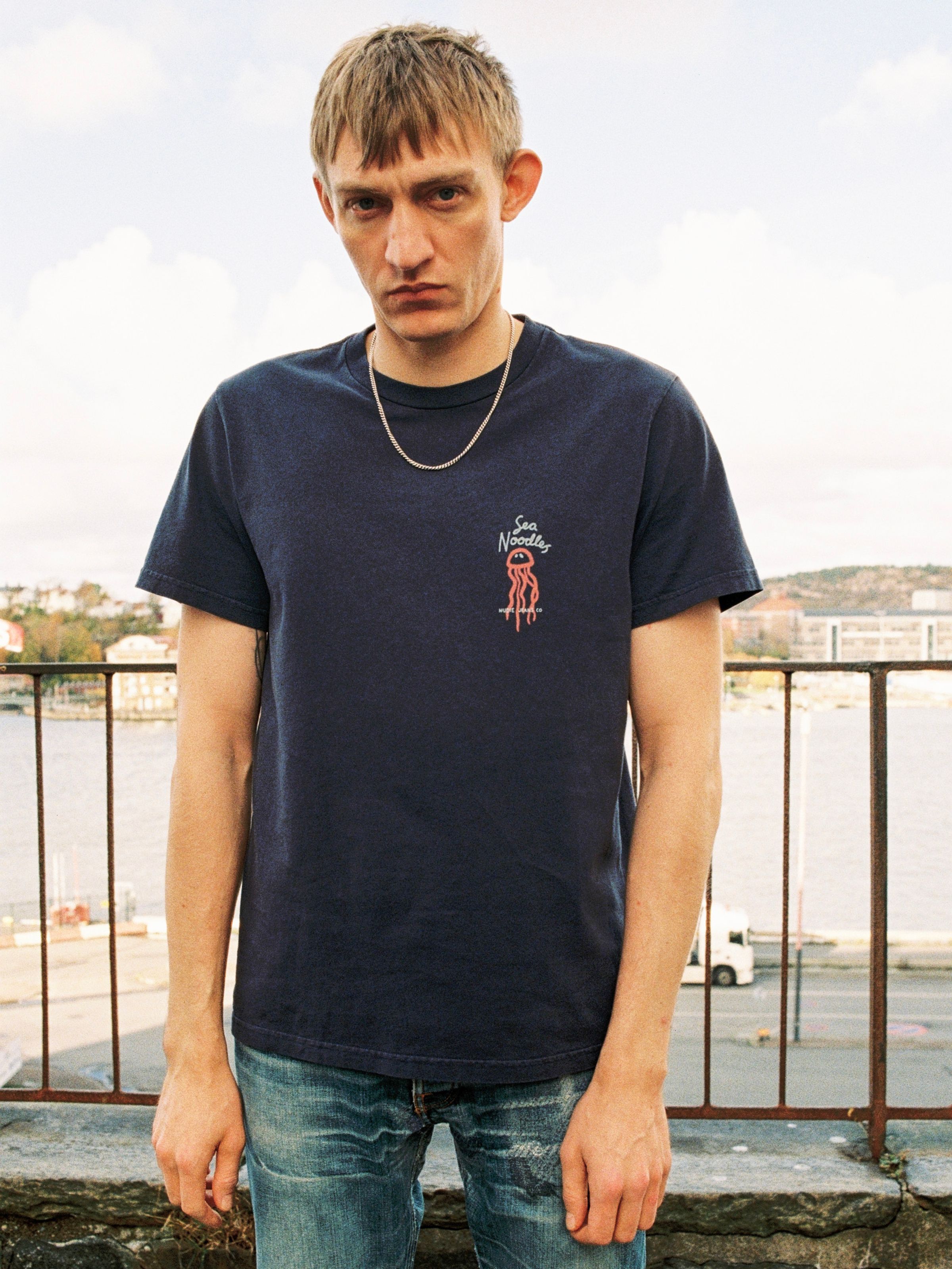 Nudie Jeans Roy Sea Noodles T-Shirt, a men's regular fit t-shirt in dark blue, shown on a model from the front.