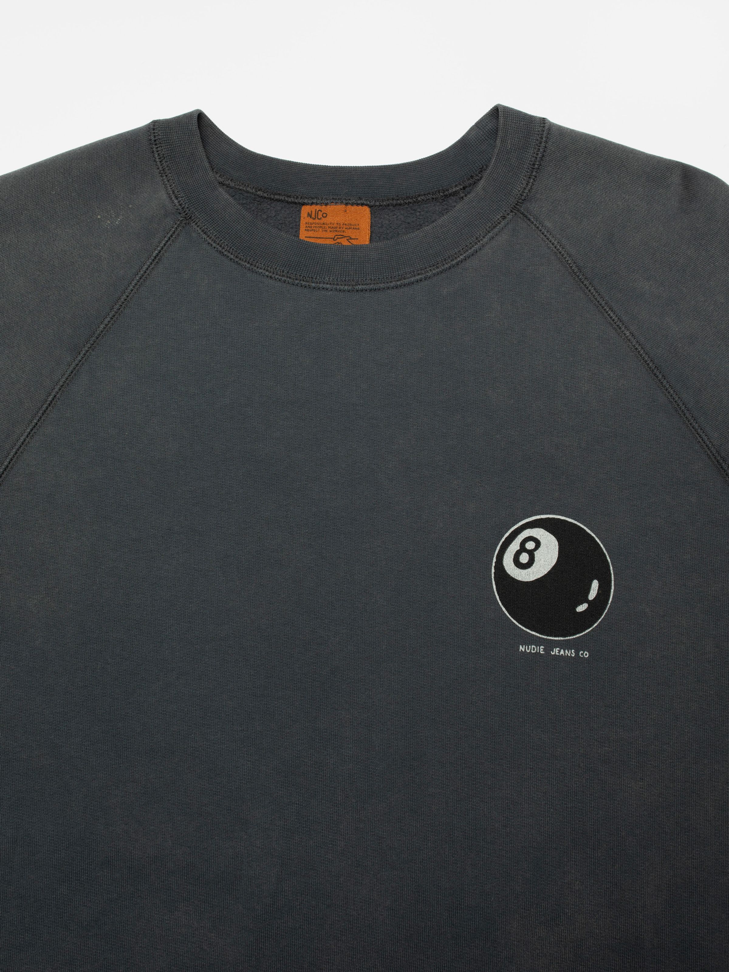 Nudie Jeans Palle Sweatshirt Knock-Topus in Antracite, close-up of the crew neck and 8-ball graphic on the chest.