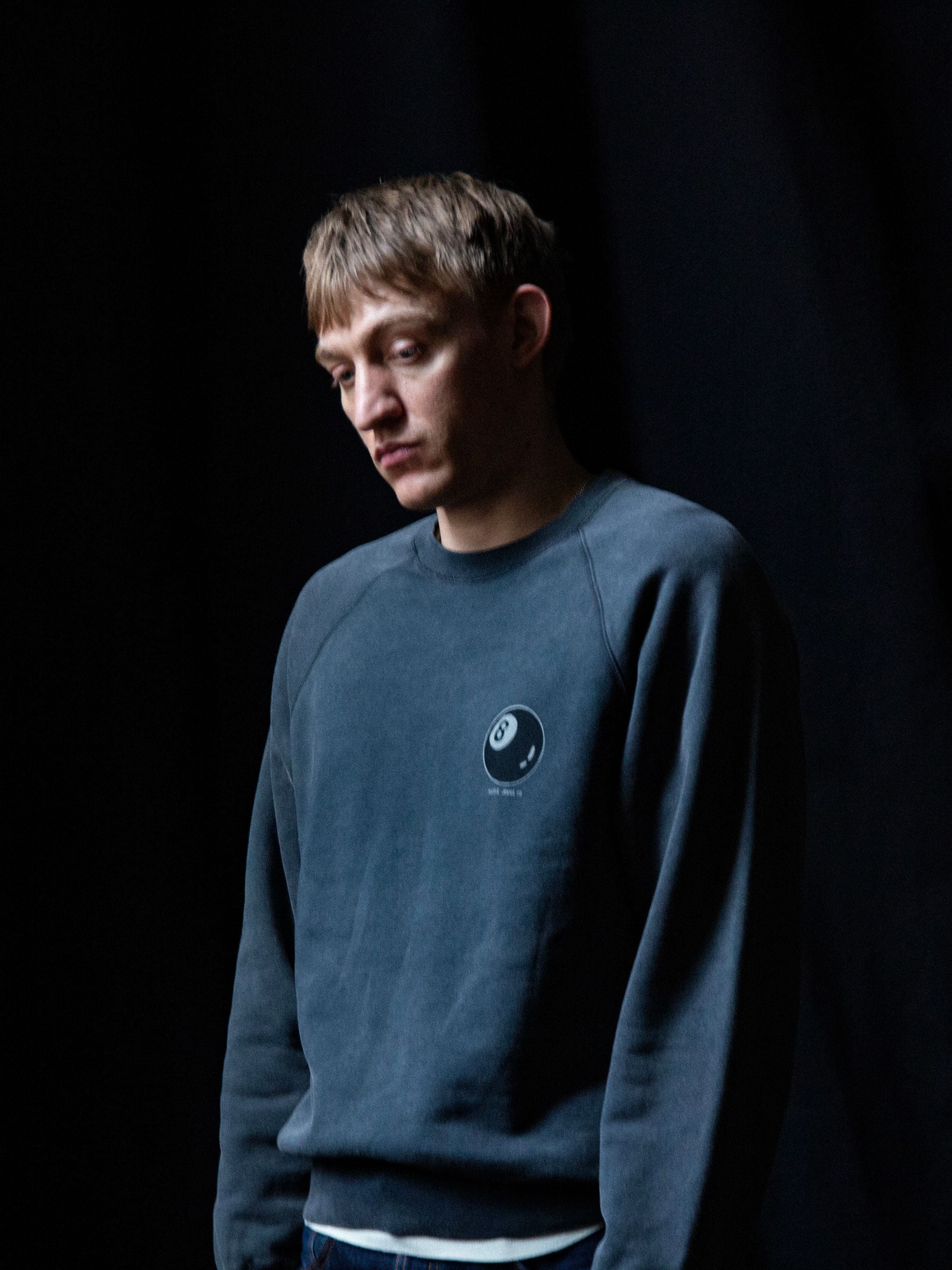 Nudie Jeans Palle Sweatshirt Knock-Topus in Antracite, a men's sweatshirt shown on a model from the chest up.