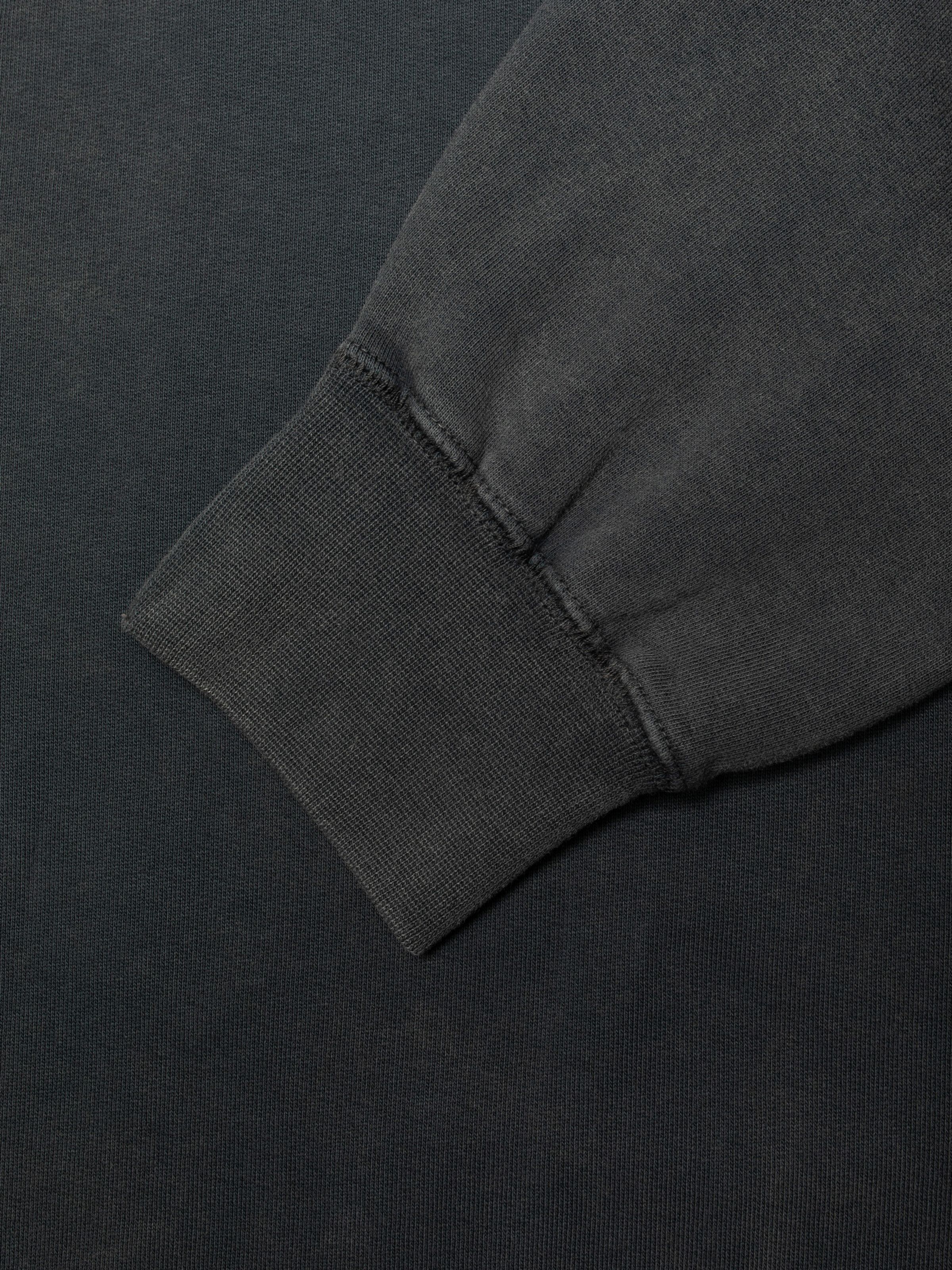 Nudie Jeans Palle Sweatshirt Knock-Topus in Antracite, showing a close-up of the ribbed sleeve cuff and faded fabric.