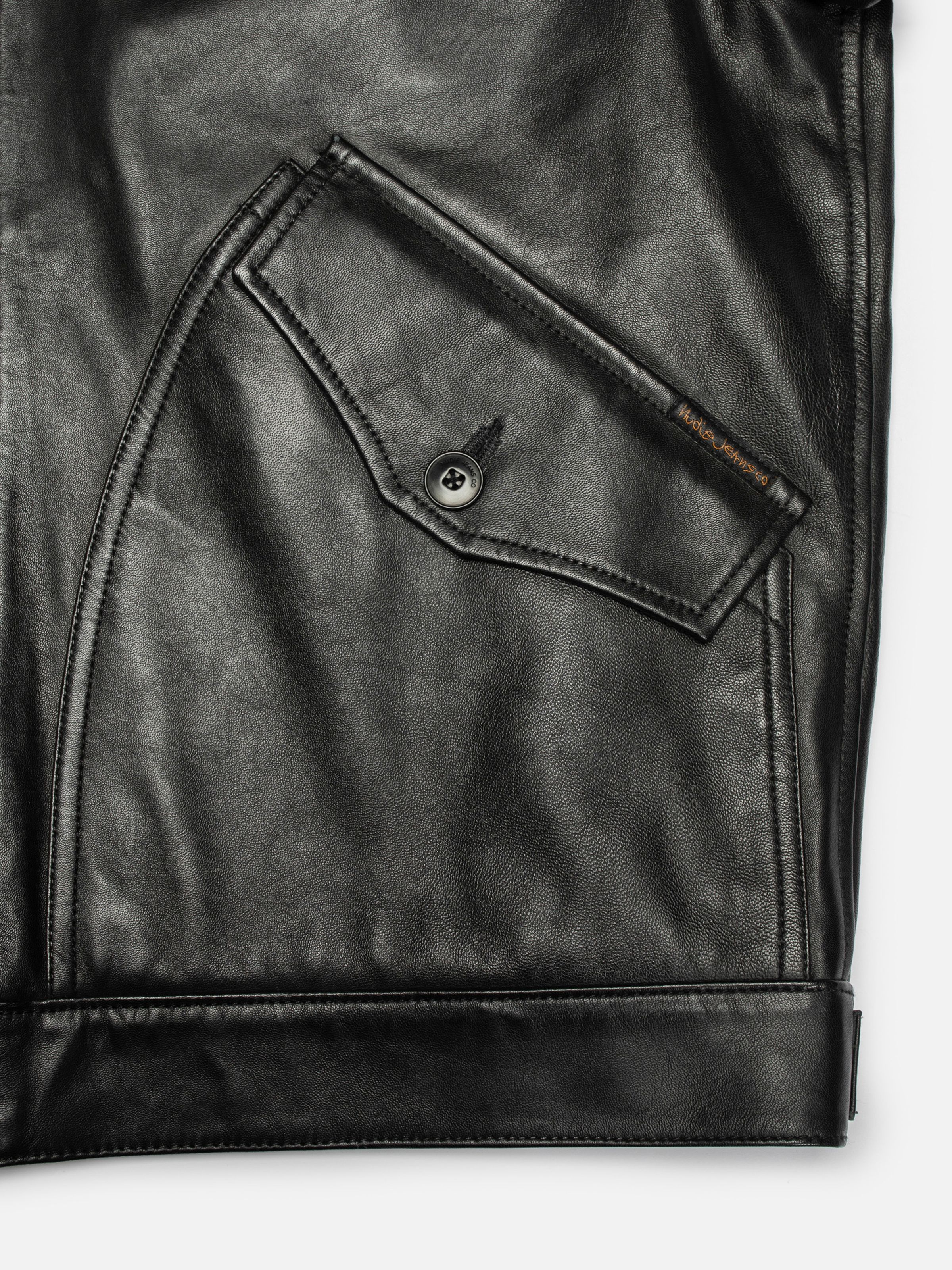 Nudie Jeans Blake Zip Jacket Leather in Black, close-up of the front pocket and hem.