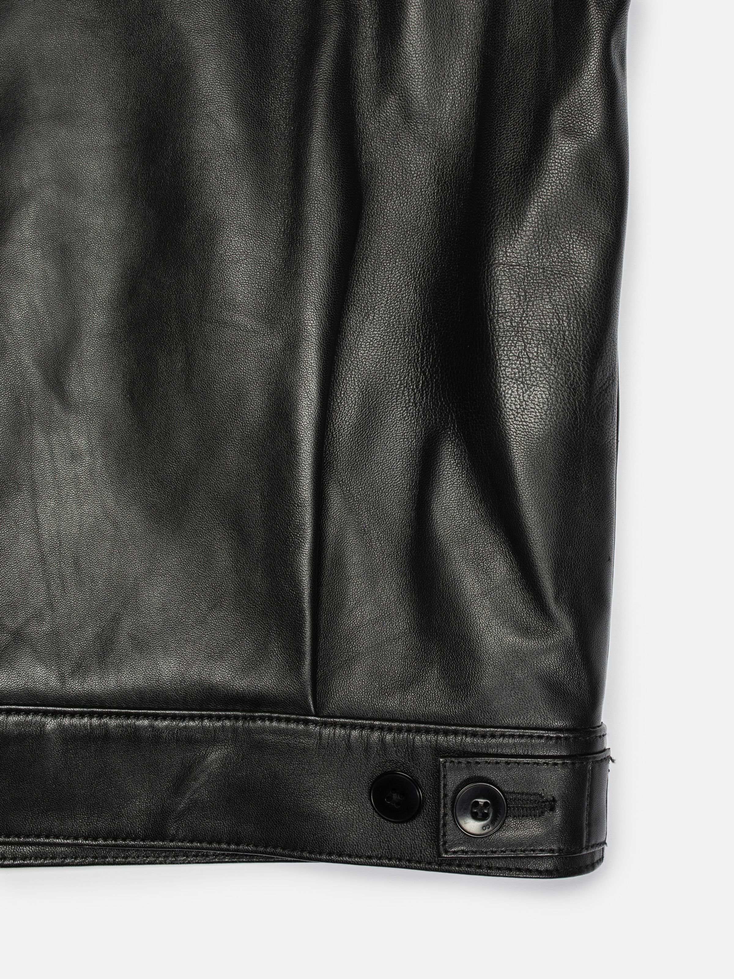 Nudie Jeans Blake Zip Jacket Leather Black, close-up of the adjustable side tab at the hem.
