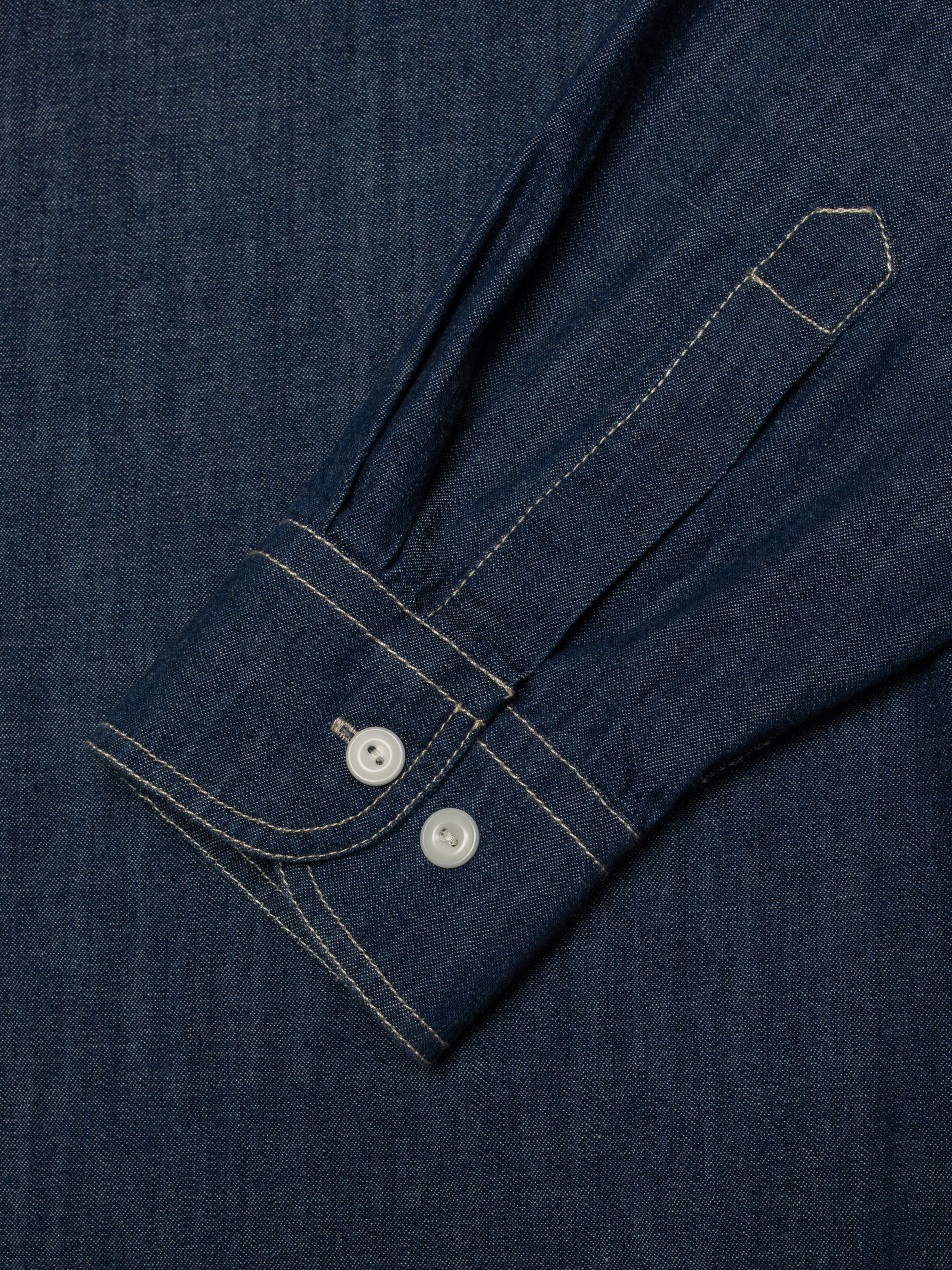 Nudie Jeans Julian Denim Shirt Rinsed, a close-up of the sleeve cuff showing the contrast stitching and corozo buttons.