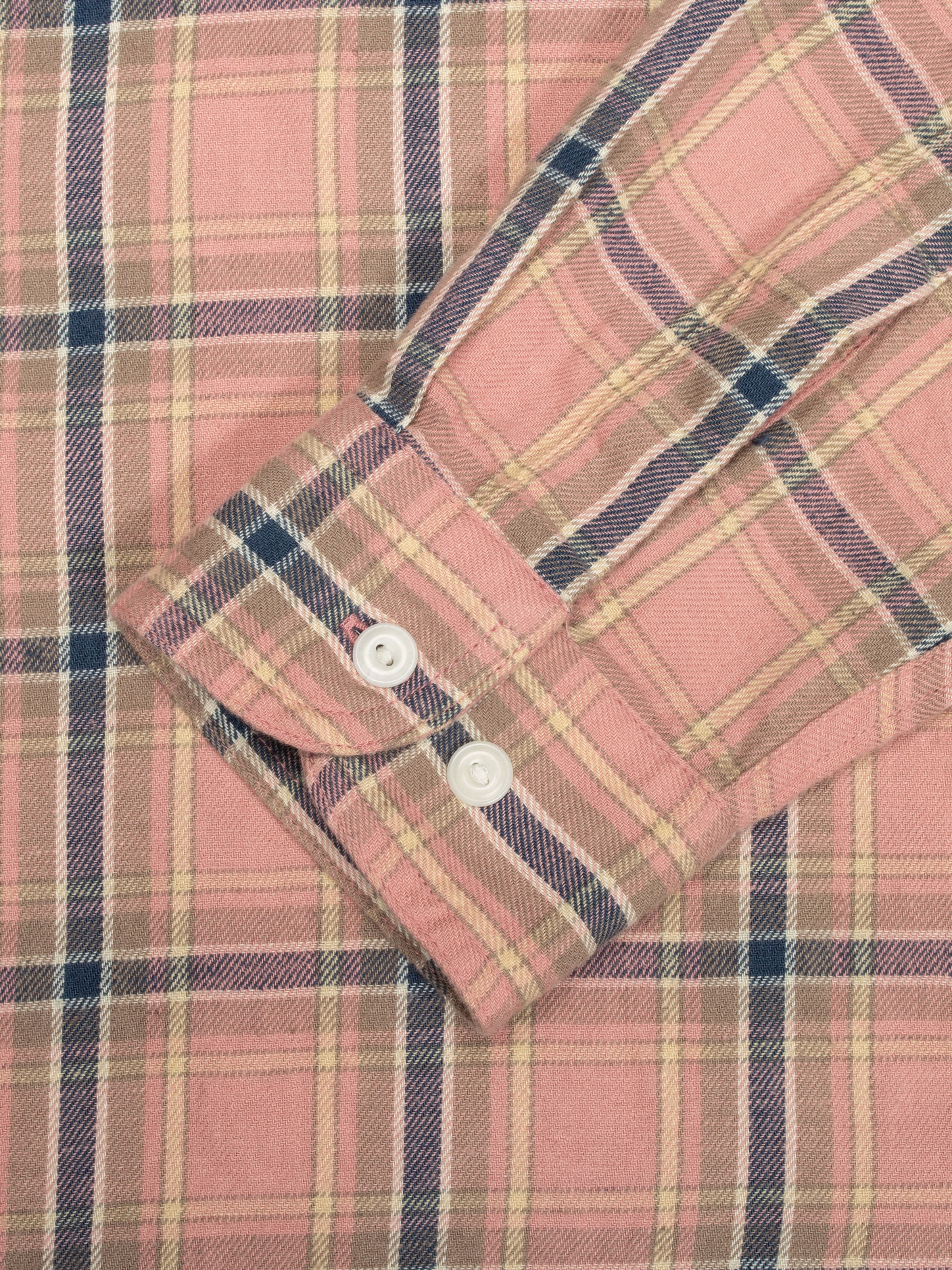 Nudie Jeans Julian Worker Shirt Checked, a close-up of the pink plaid fabric and the sleeve cuff with corozo buttons.