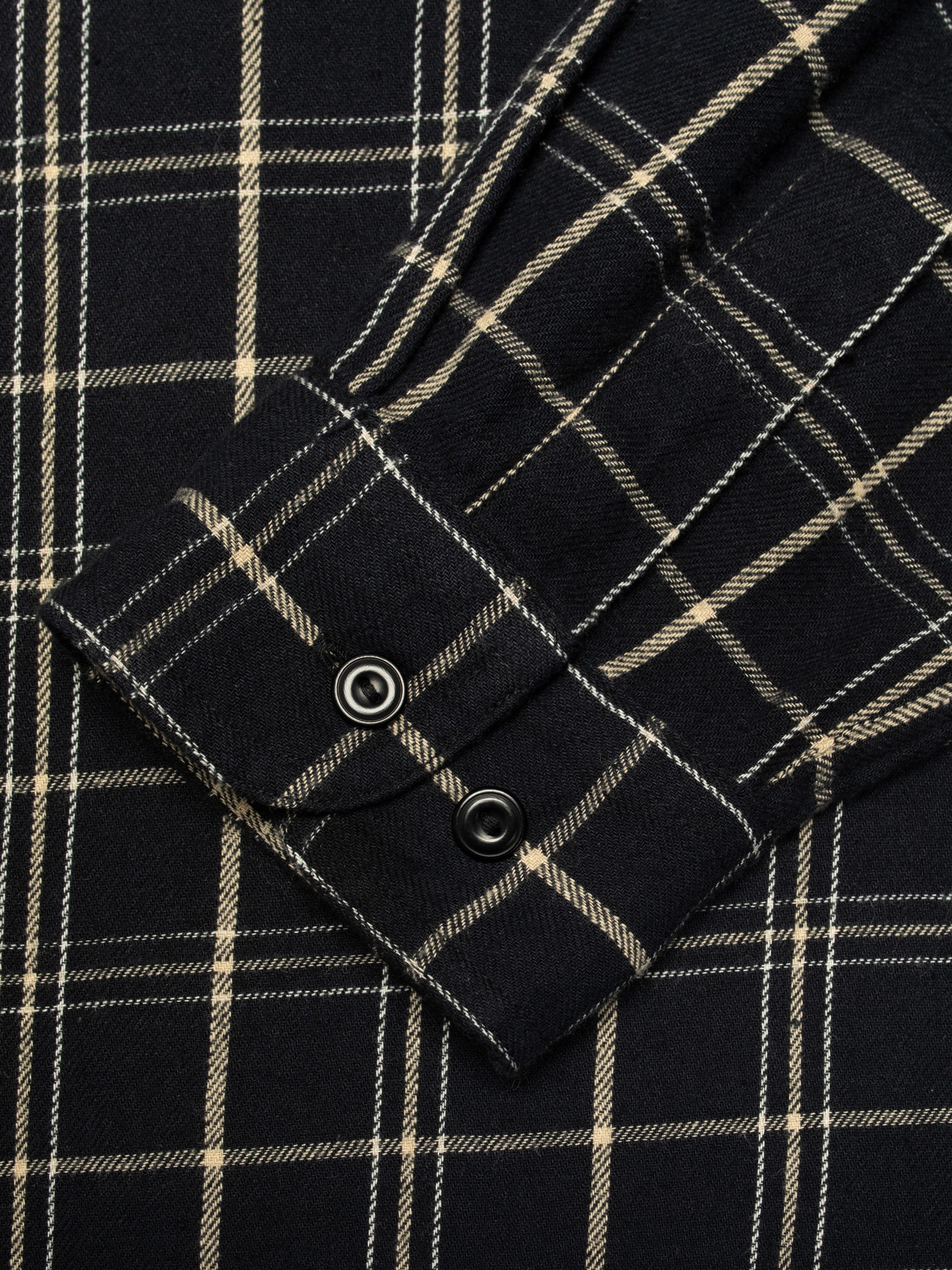 Nudie Jeans Julian Worker Shirt Checked in black, close-up of the sleeve cuff showing the fabric and snap buttons.