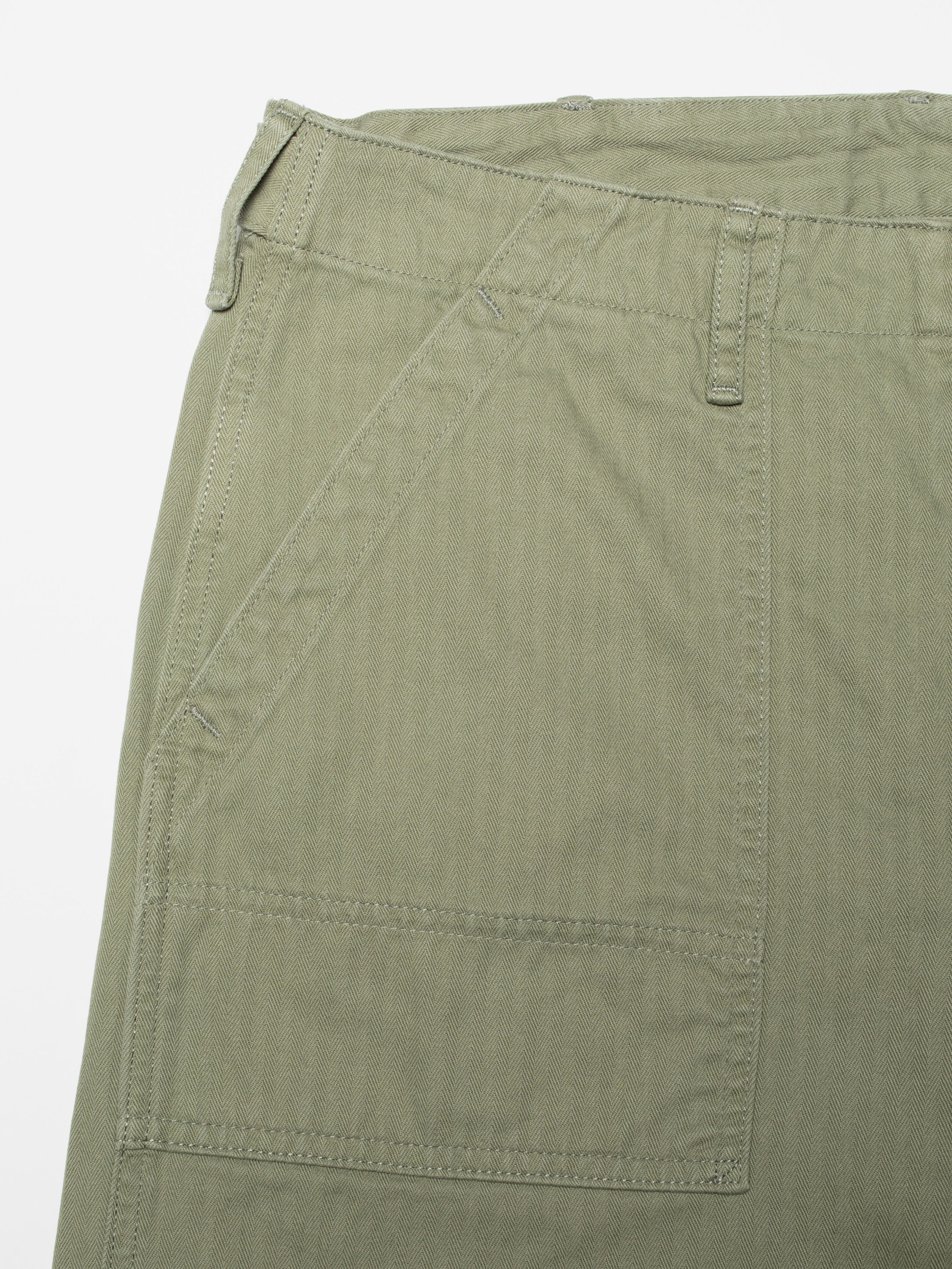 Nudie Jeans Tuff Tony Pants Pale Green, men's loose fit pants, showing a close-up of the front pocket and herringbone twill.