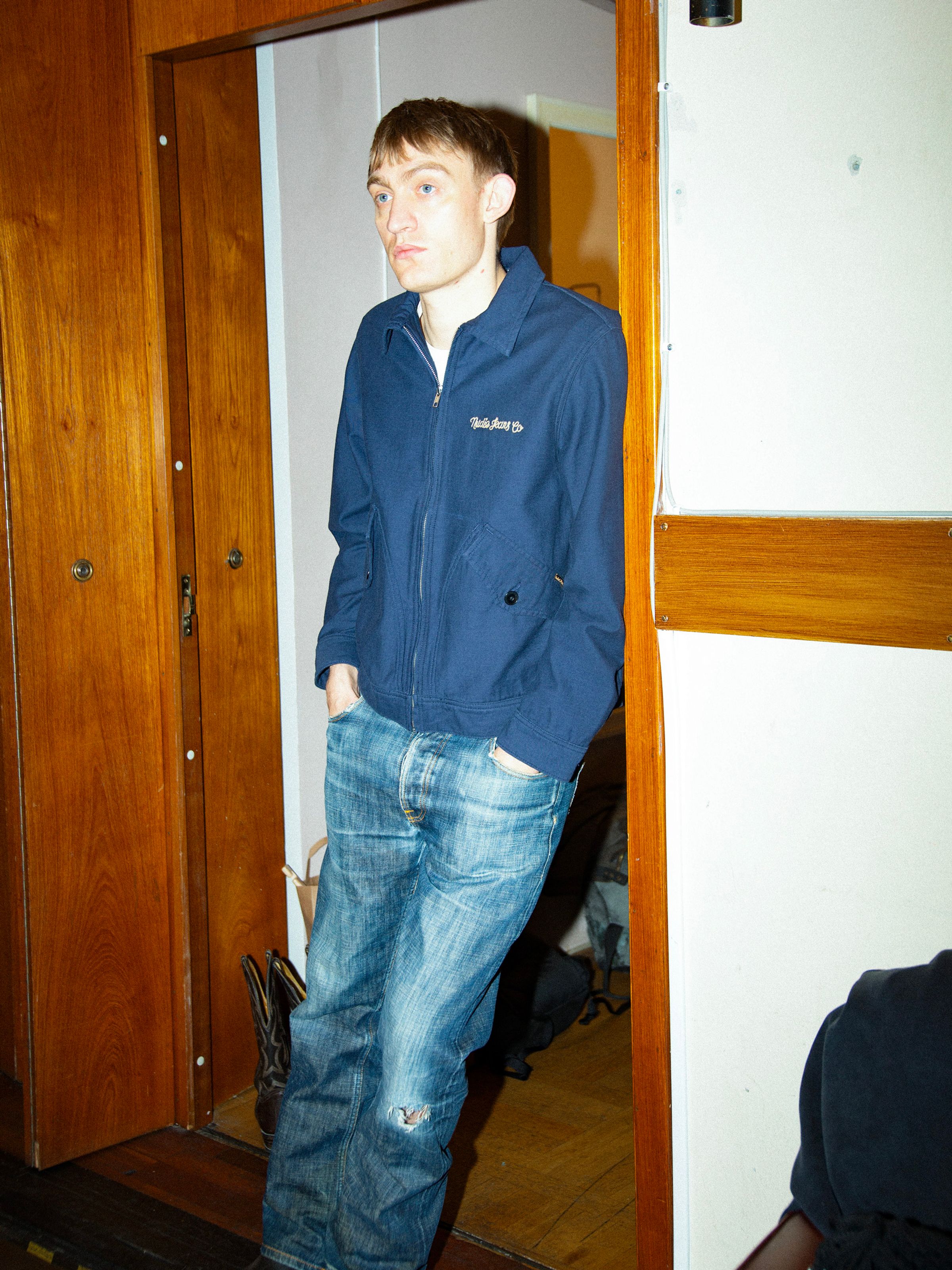 Nudie Jeans Blake Zip Jacket Back Sateen Navy, men's regular fit jacket shown on a model in a lifestyle shot.