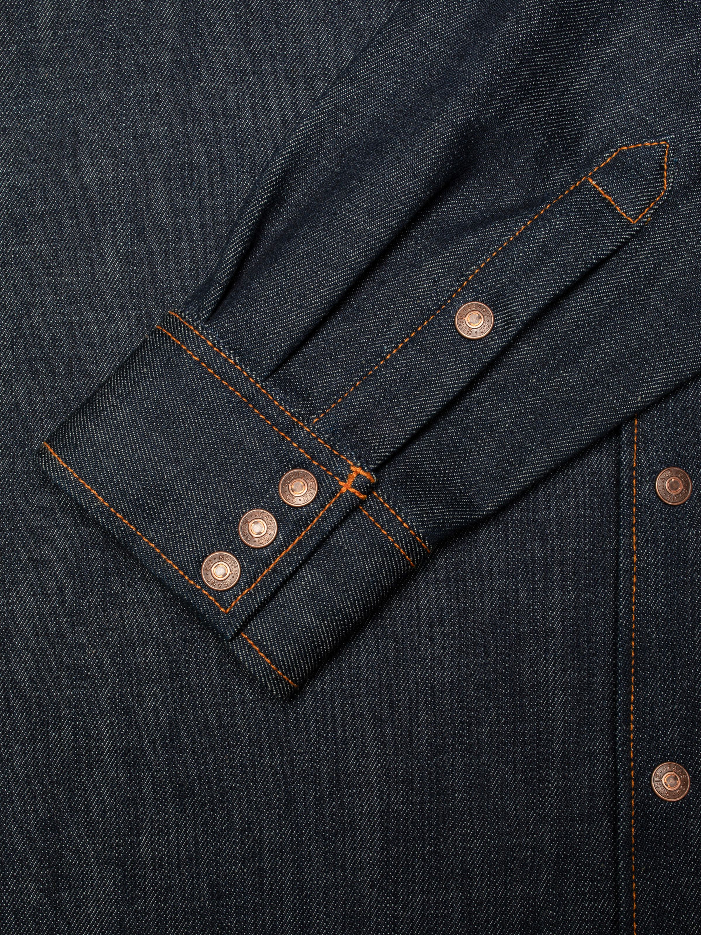 Nudie Jeans Gunnar Denim Shirt Dry Streaky, close-up of the sleeve cuff showing the orange stitching and copper buttons.