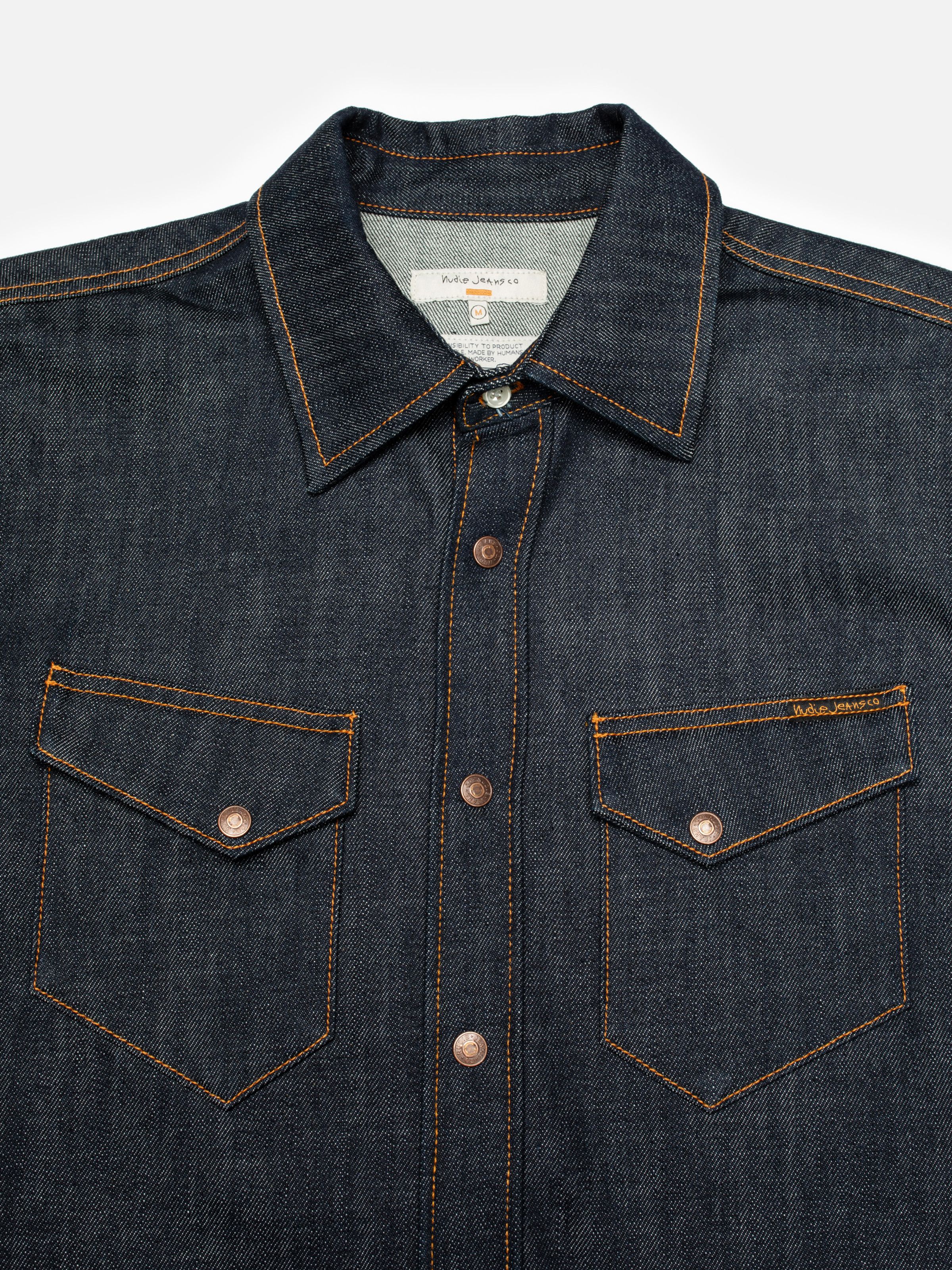 Nudie Jeans Gunnar Denim Shirt Dry Streaky, a close-up view of the collar and asymmetrical chest pockets.