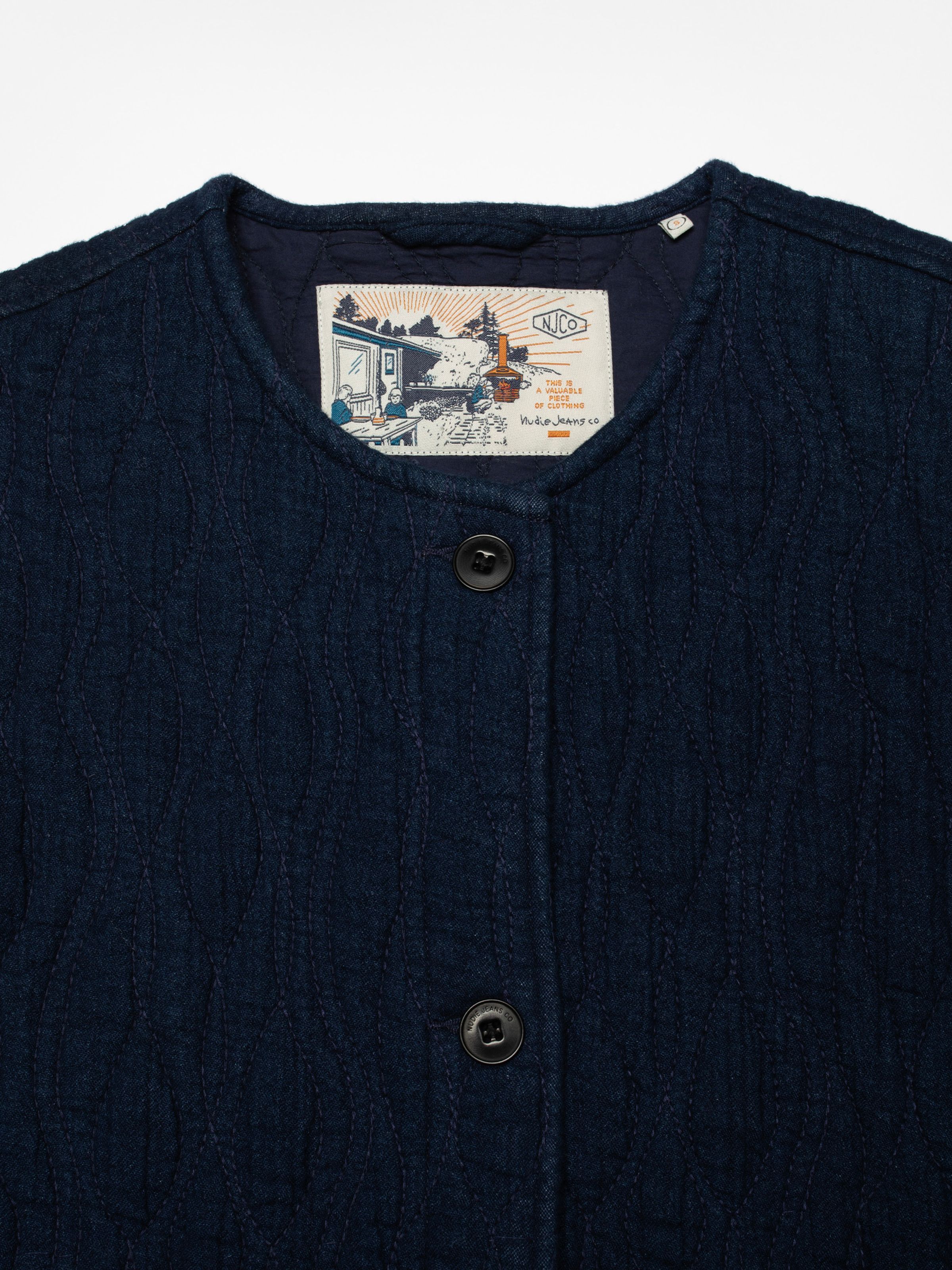 Nudie Jeans Sandra Jacket Indigo Quilt Blue, close-up of the quilted texture, collar, and inner brand label.