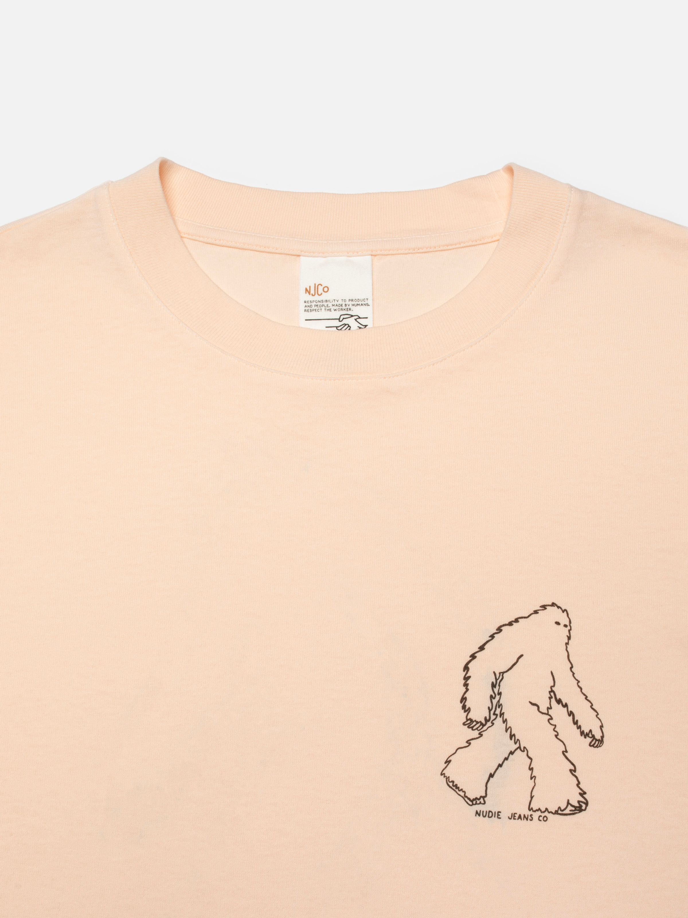 Nudie Jeans Karita Icy Long Sleeve T-Shirt in pink, a close-up showing the Yeti chest print and neckline detail.