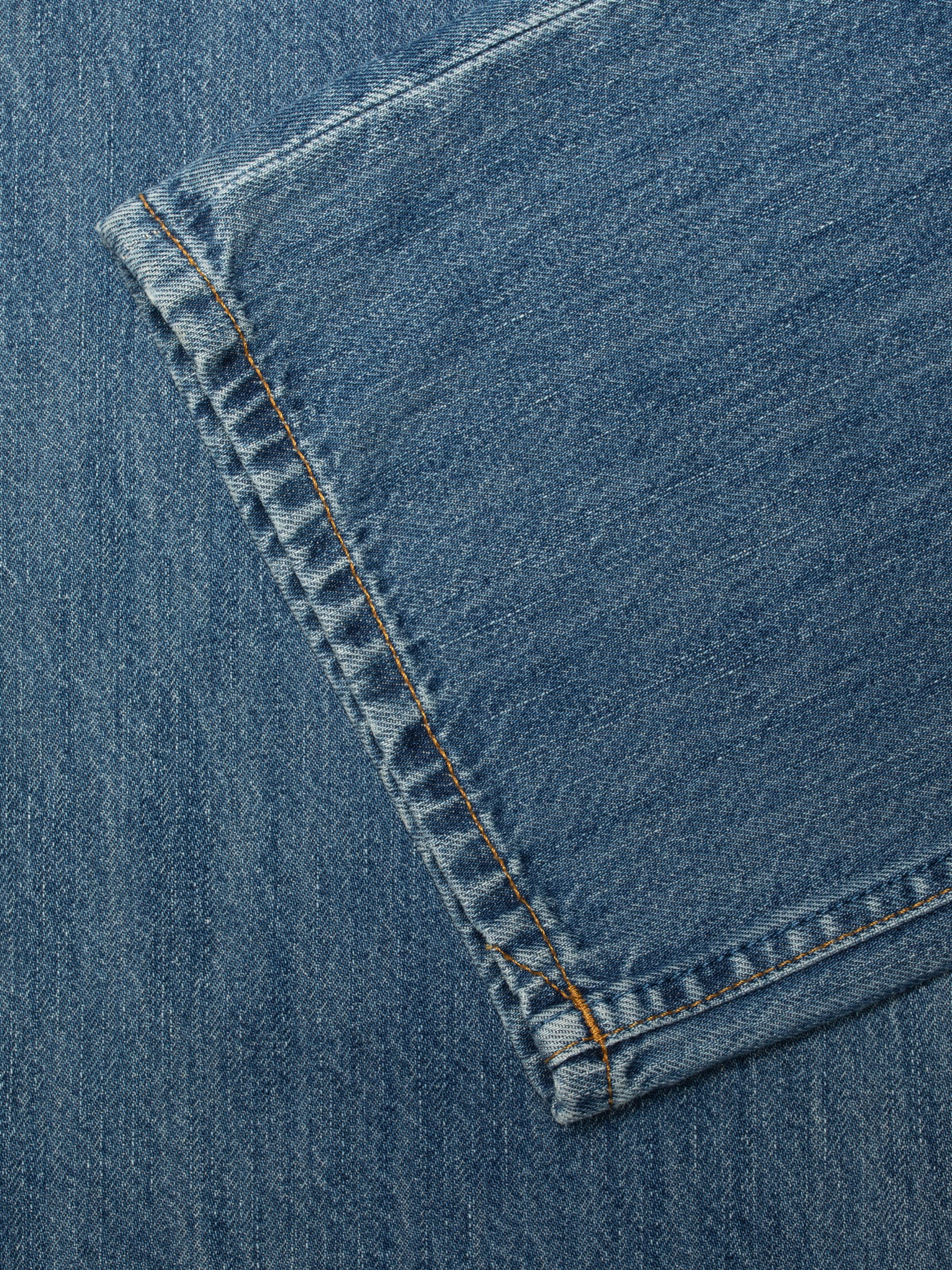 Nudie Jeans Clean Eileen Clear Skies, Damenjeans mit lockerer Passform, Nahaufnahme des Saums und der tabakfarbenen Nähte.