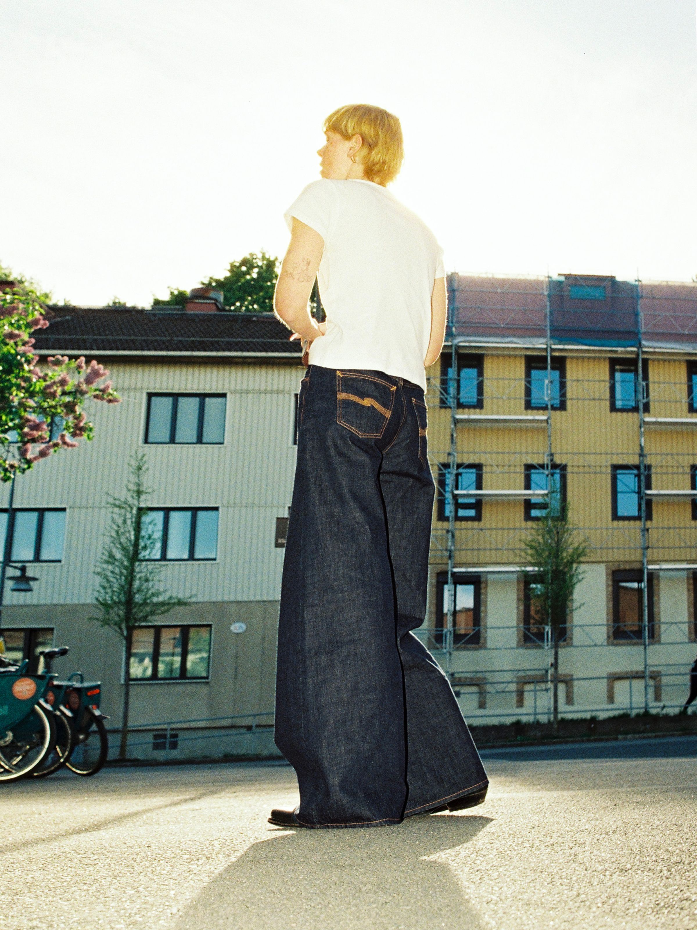 Nudie Jeans Sonic Sue One Wash, women's wide A-line jeans shown from the back on a model in an urban setting.