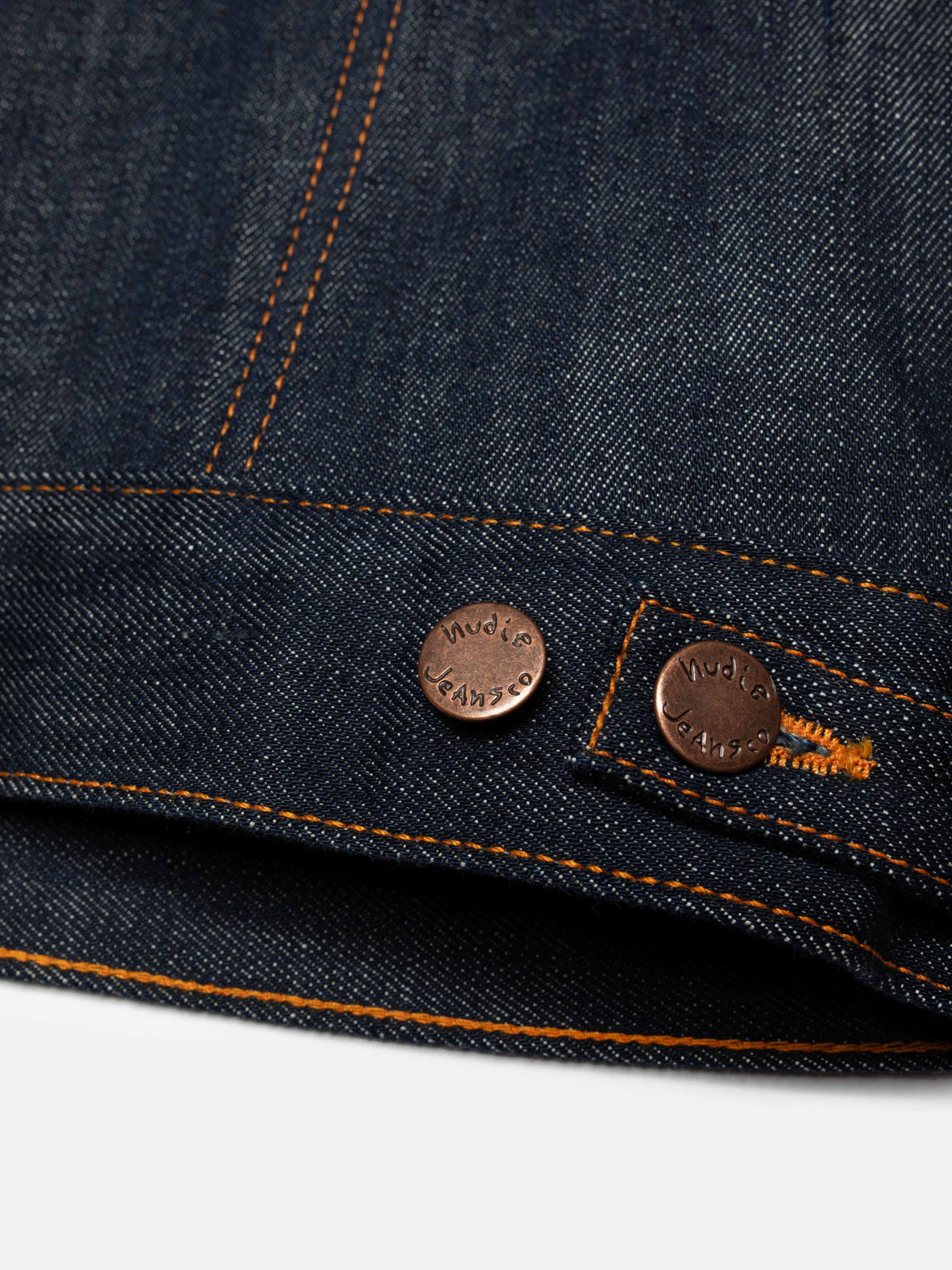 Nudie Jeans Britta Denim Jacket Dry Streaky, women's slim fit jacket, showing a close-up of the hem and branded buttons.
