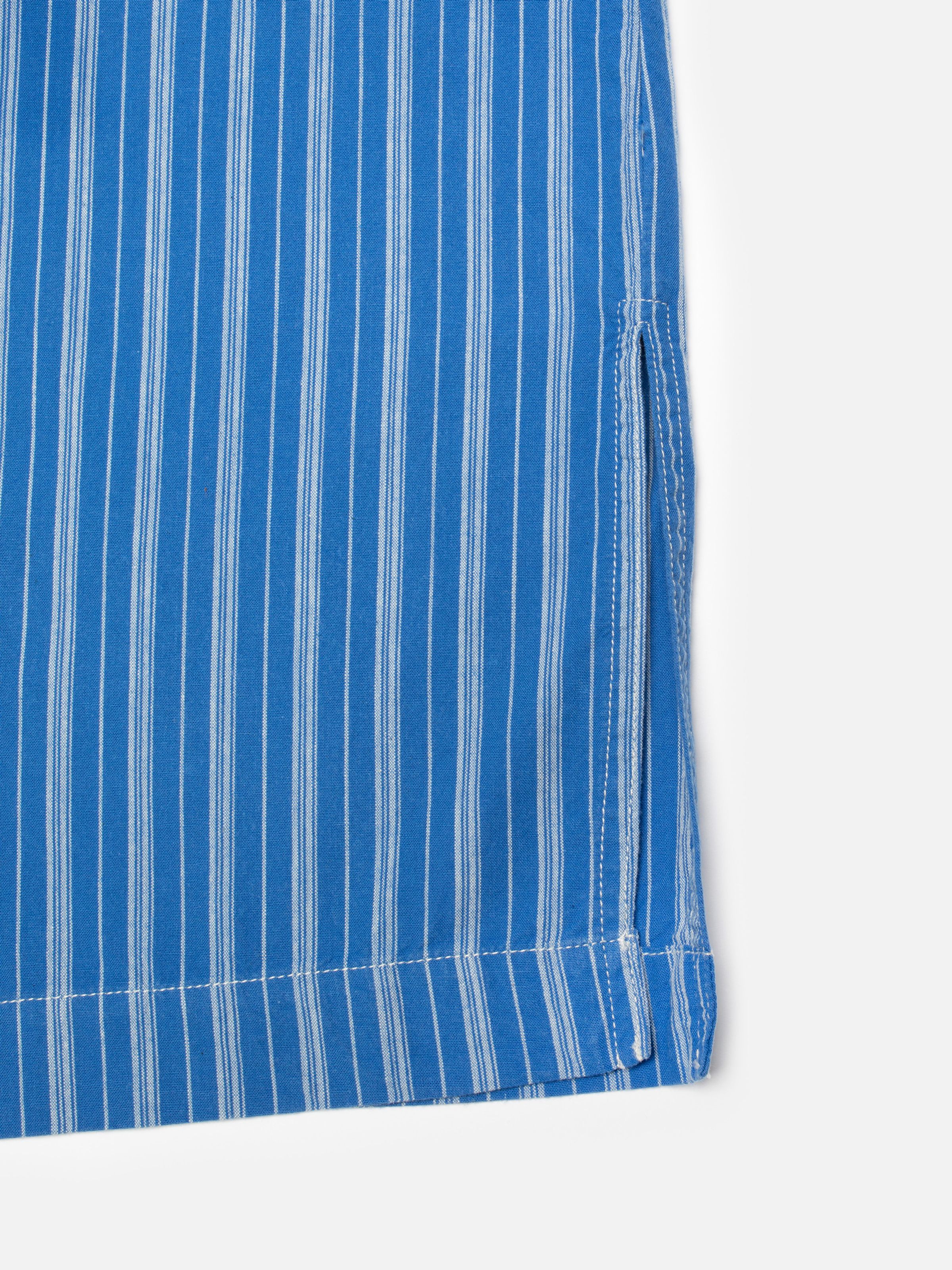 Nudie Jeans Danielle Dress Striped in Blue/Offwhite, close-up of the hem showing the side slit detail.