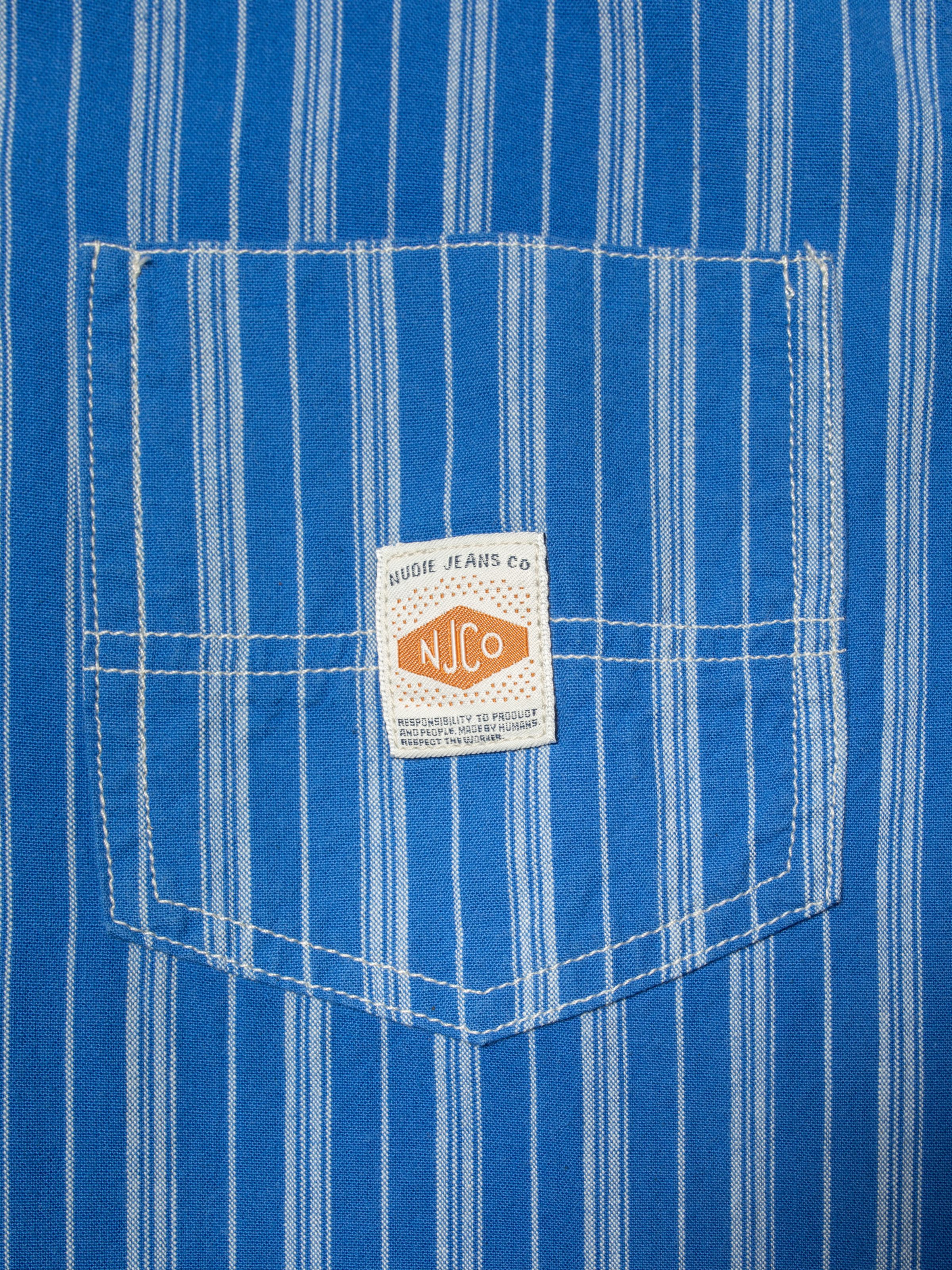 Nudie Jeans Danielle Dress Striped in Blue/Offwhite, close-up of the chest pocket showing the striped fabric and logo label.