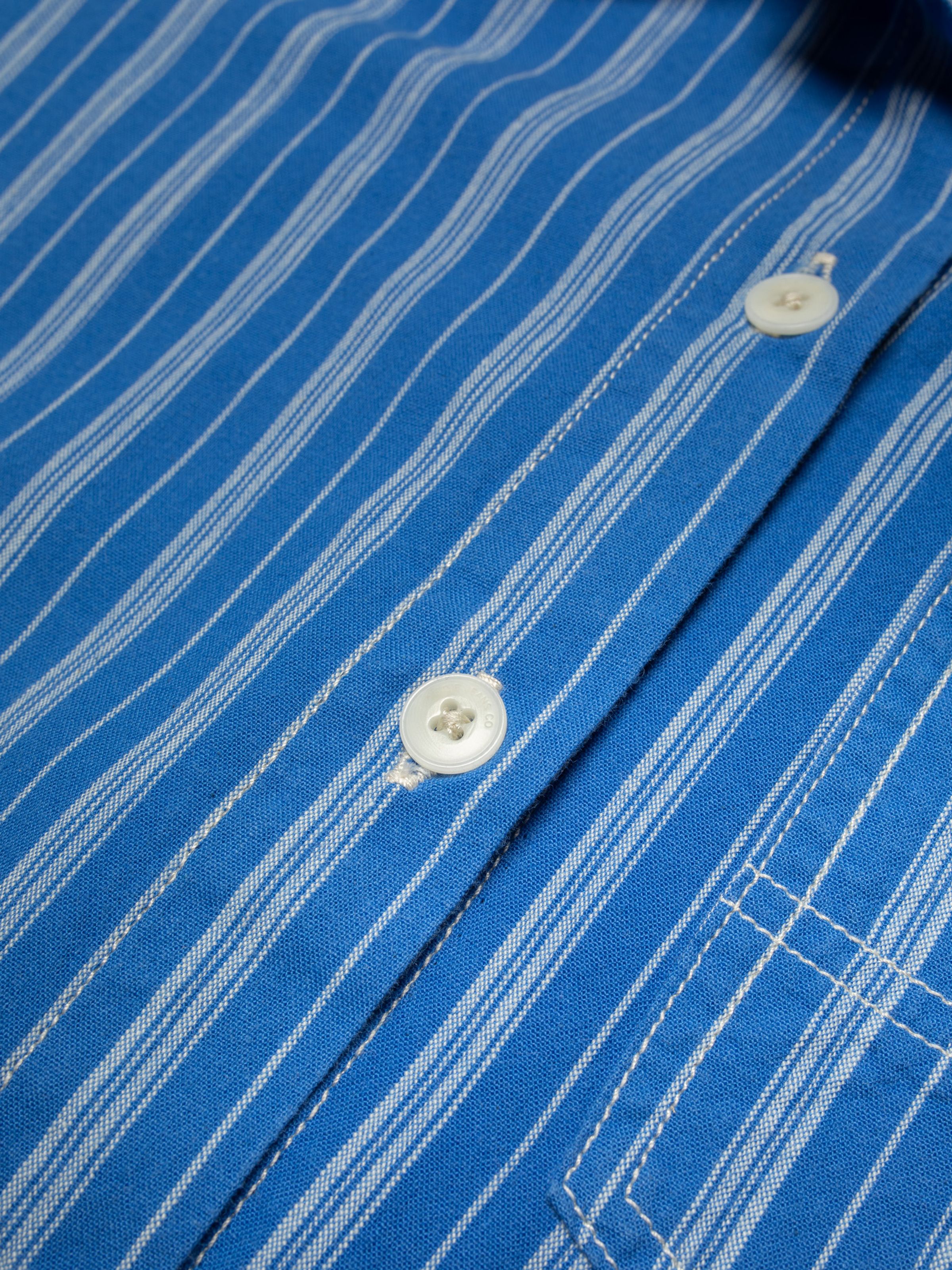 Nudie Jeans Danielle Dress Striped in Blue/Offwhite, close-up of the striped fabric, corozo buttons, and button placket.