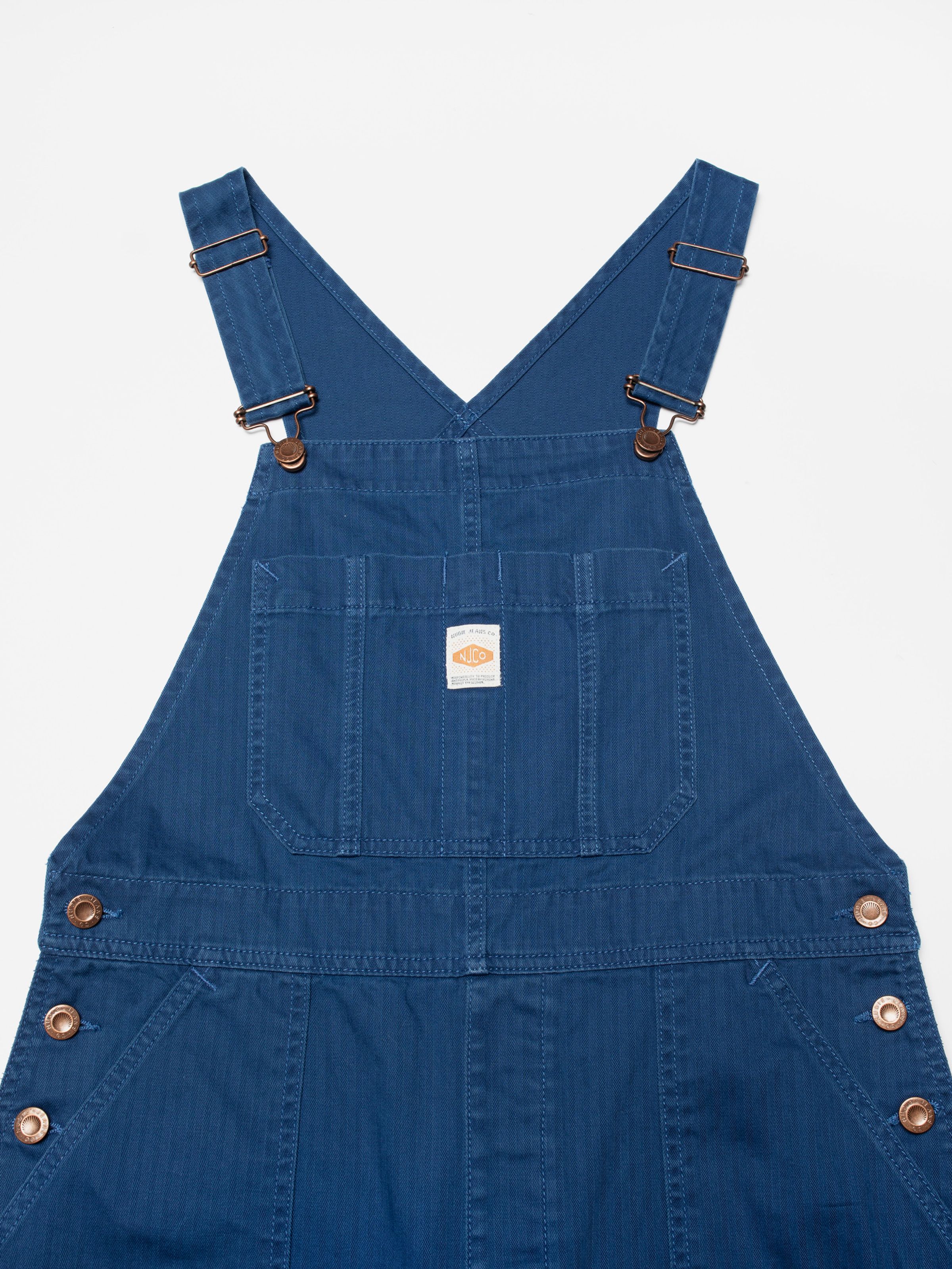 Nudie Jeans Klara Dungarees Herringbone, women's dungarees in blue, close-up view of the herringbone fabric on the front bib.
