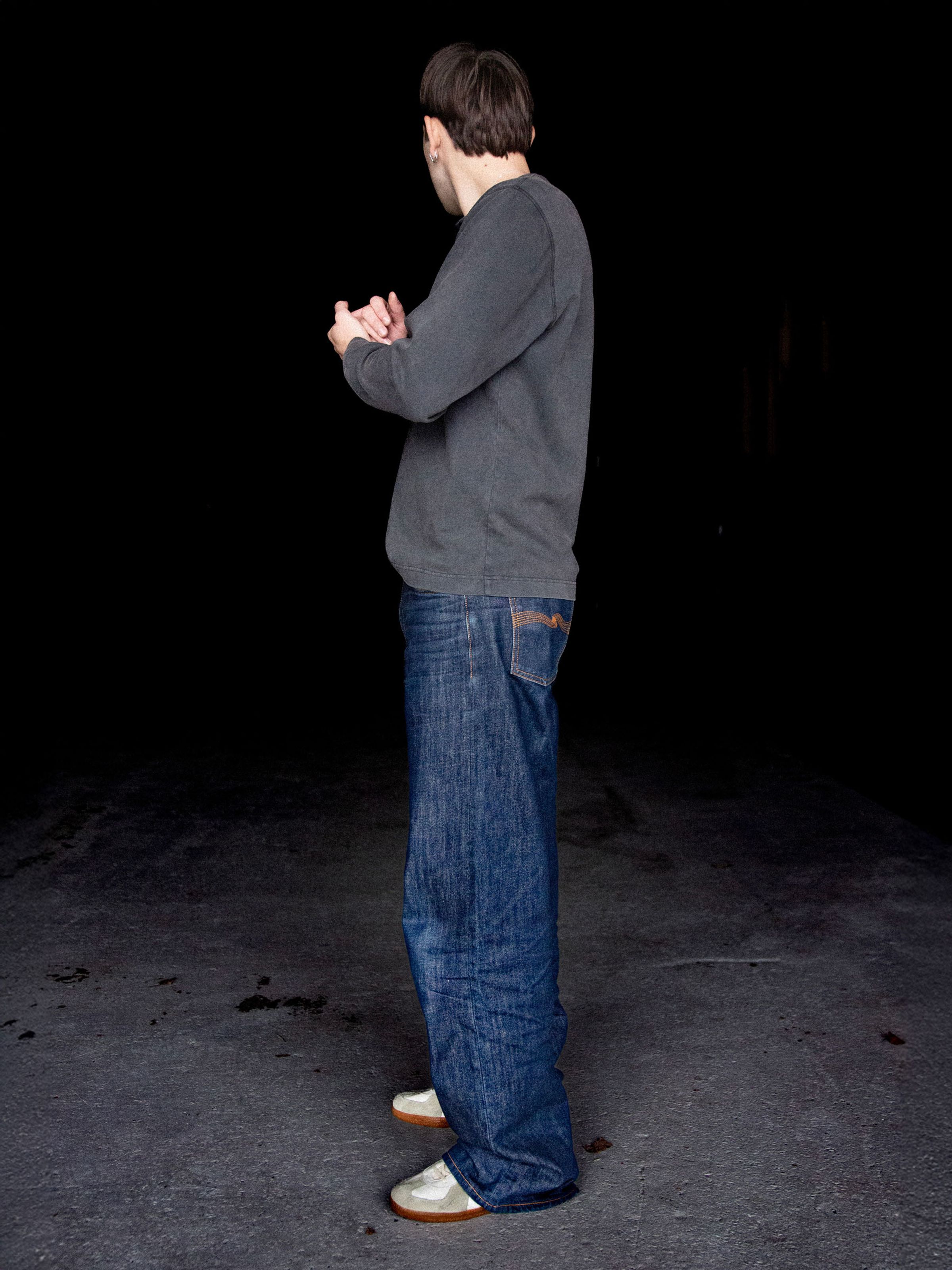 Nudie Jeans Loud Larry Dry Streaky, loose wide-leg jeans in blue organic cotton rigid denim, side view on a model.