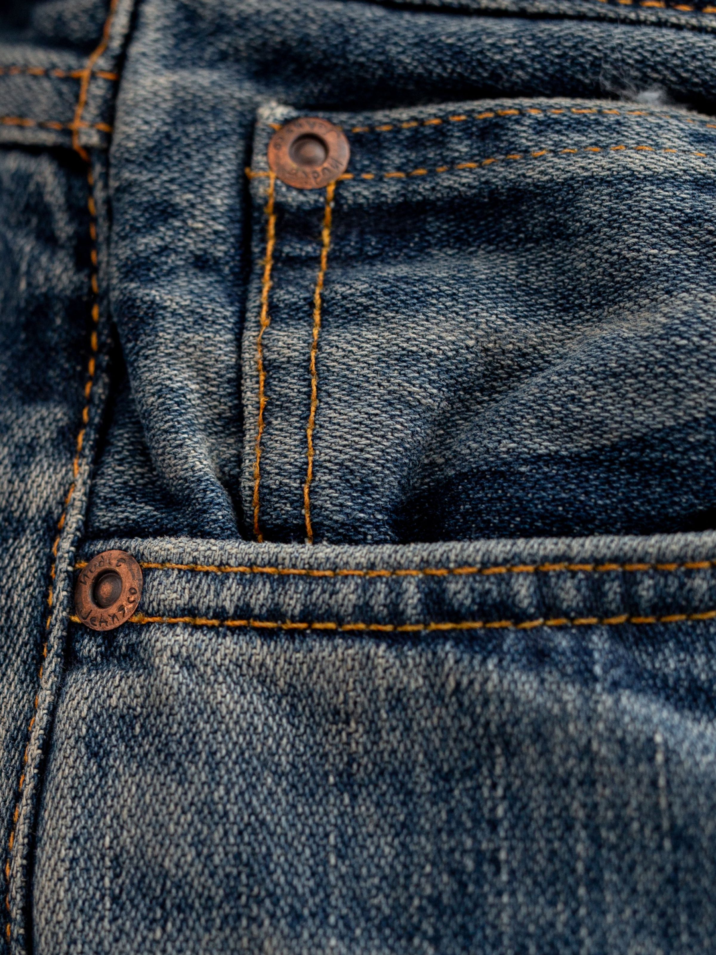 Nudie Jeans Gritty Jackson Sand Tracks, men's regular fit jeans, showing a close-up detail of the front coin pocket.