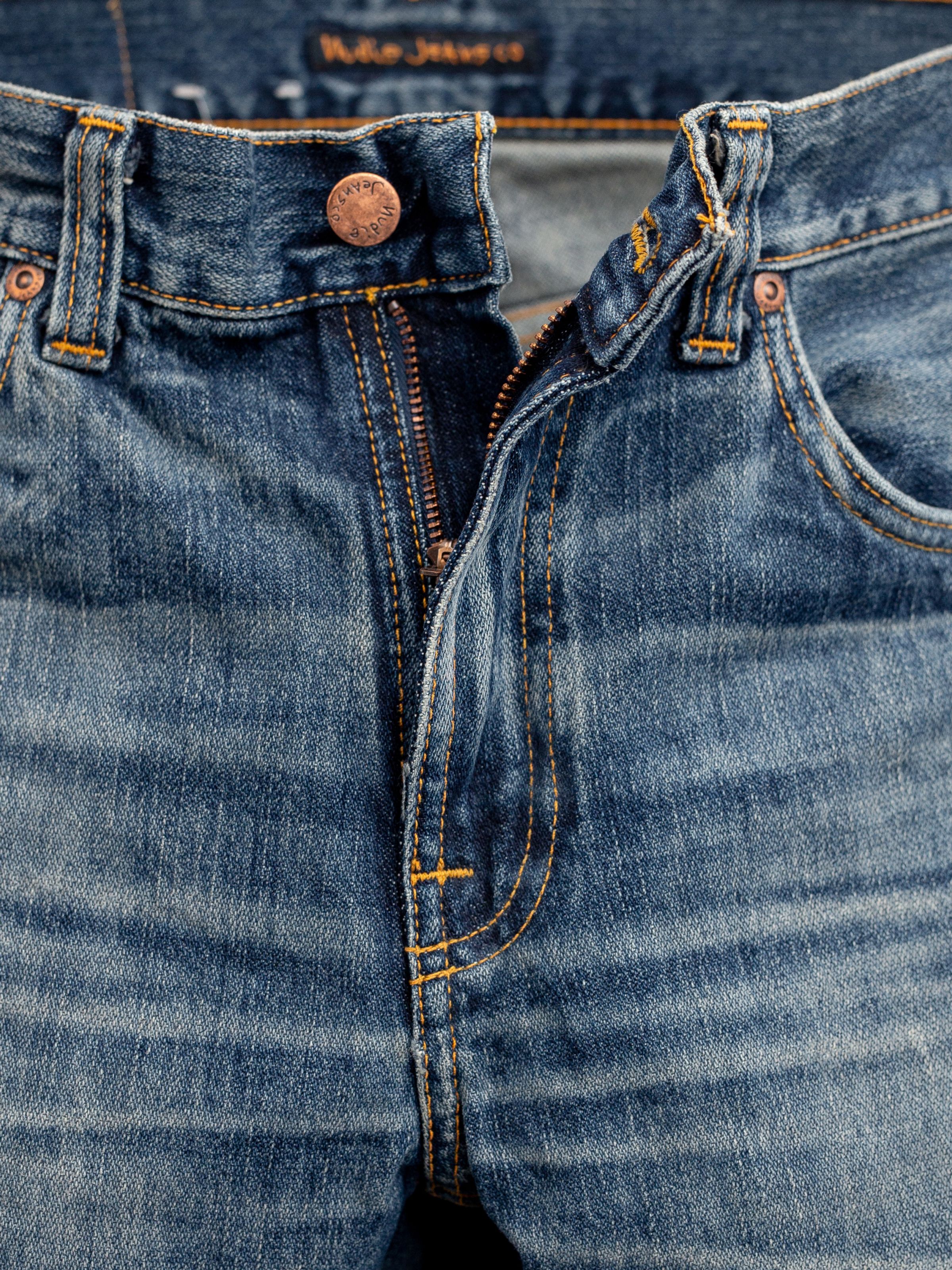 Nudie Jeans Gritty Jackson Sand Tracks, men's regular fit jeans, showing a close-up of the zipper fly and copper button.