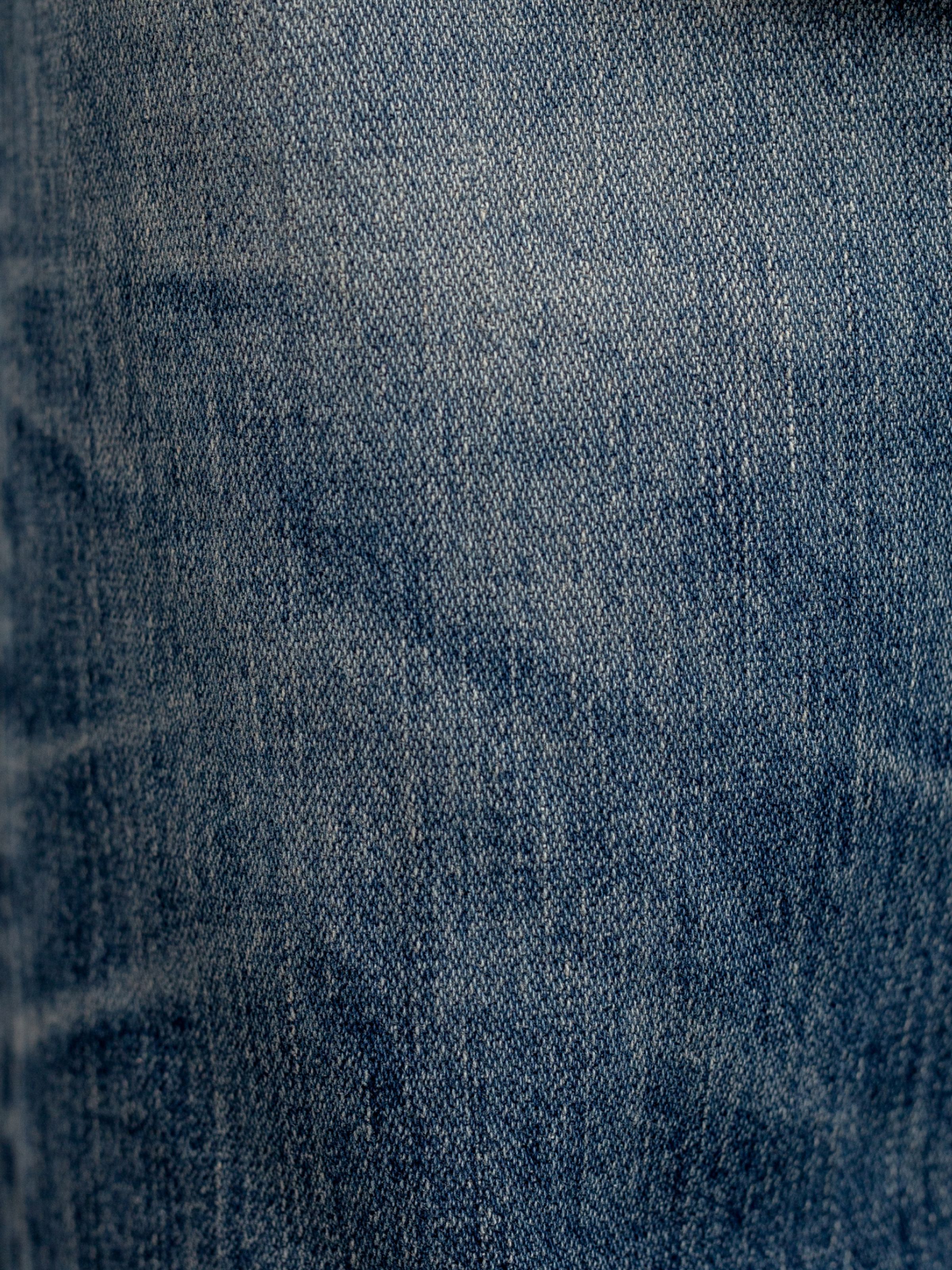 Nudie Jeans Gritty Jackson Sand Tracks, men's regular fit jeans, showing a close-up of the washed denim fabric.